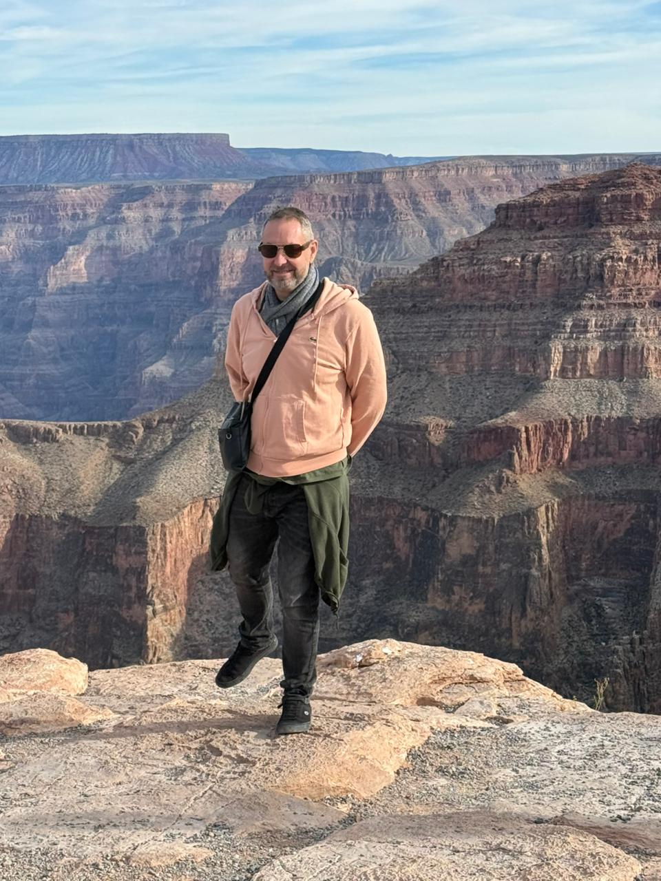 un homme debout au sommet d'une falaise