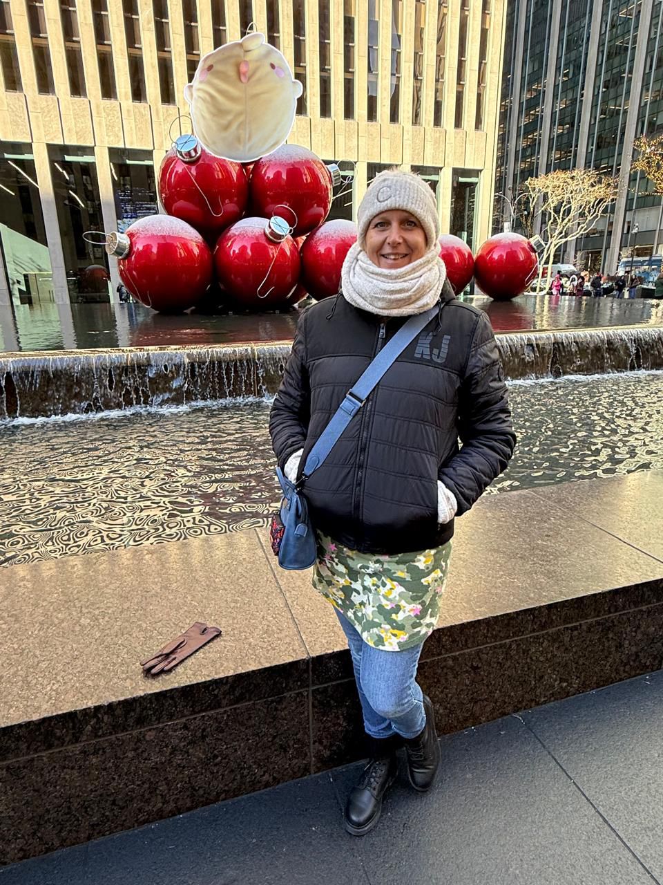 Manhattan, New York — une femme debout devant une fontaine avec des ballons rouges