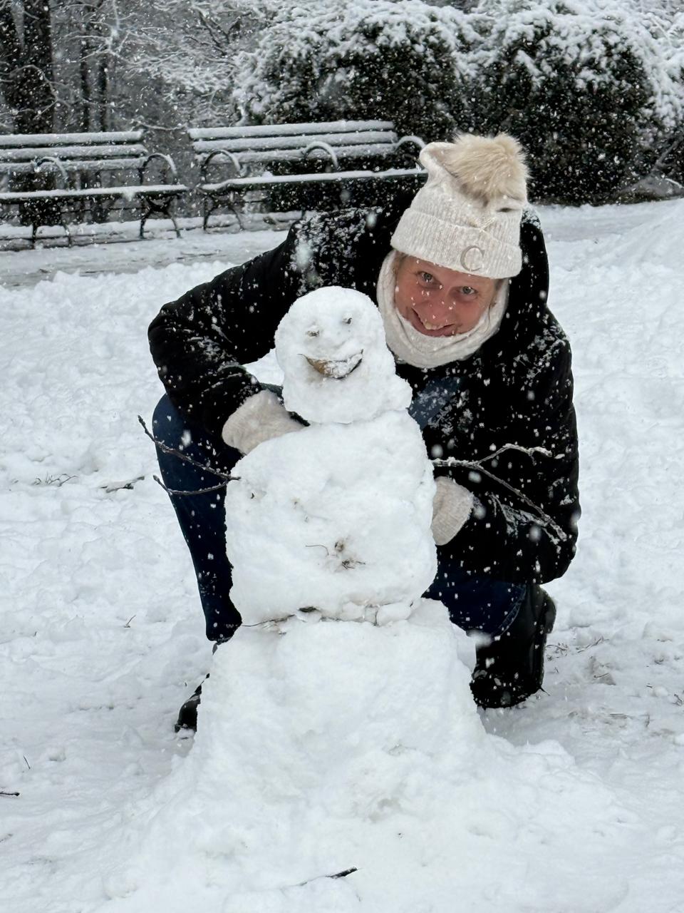Manhattan, New York — un homme à genoux en train de construire un bonhomme de neige