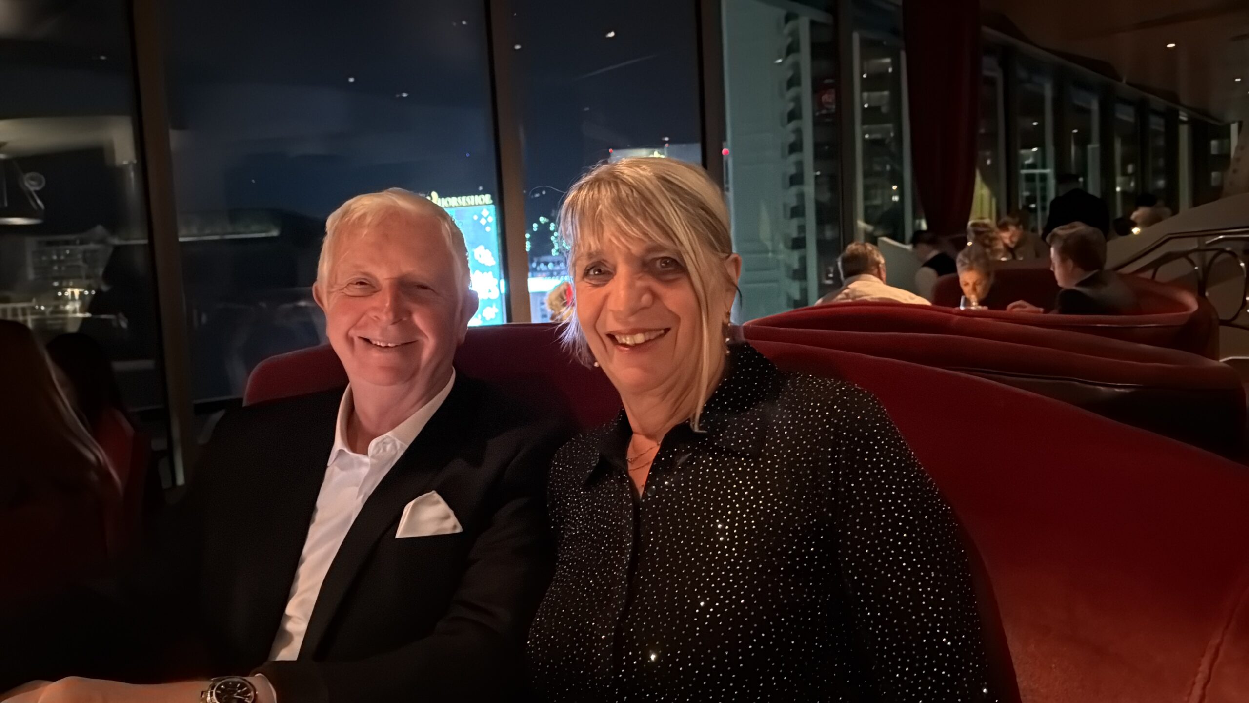 Midtown UNLV, Paradise — un homme et une femme assis sur un canapé rouge