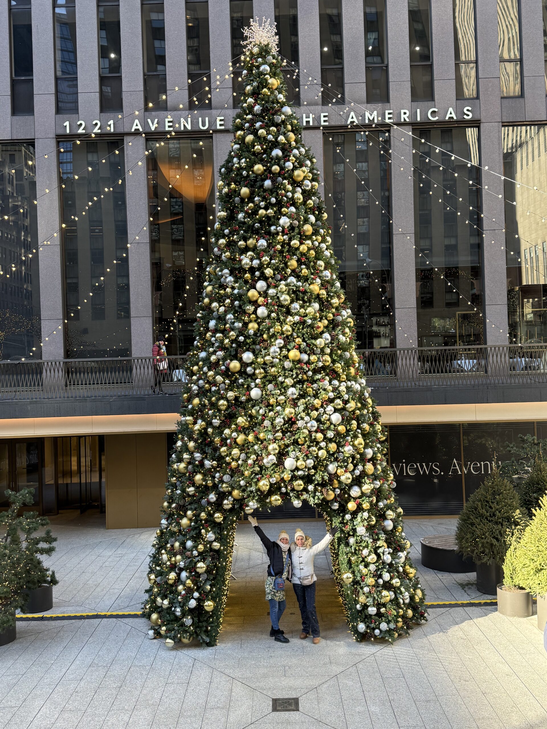 Manhattan, New York — un homme debout à côté d'un sapin de Noël