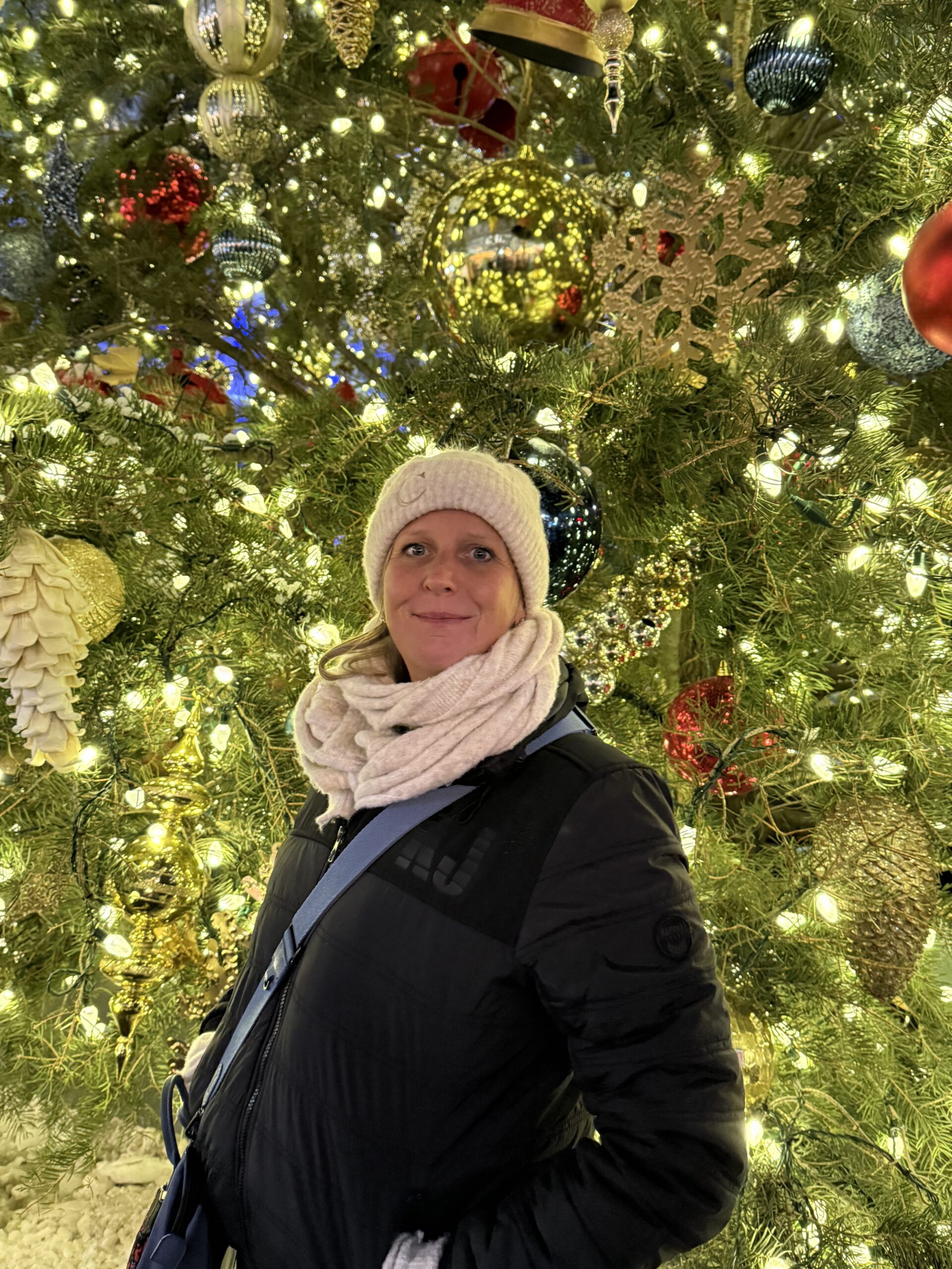 Manhattan, New York — une femme debout devant un sapin de Noël
