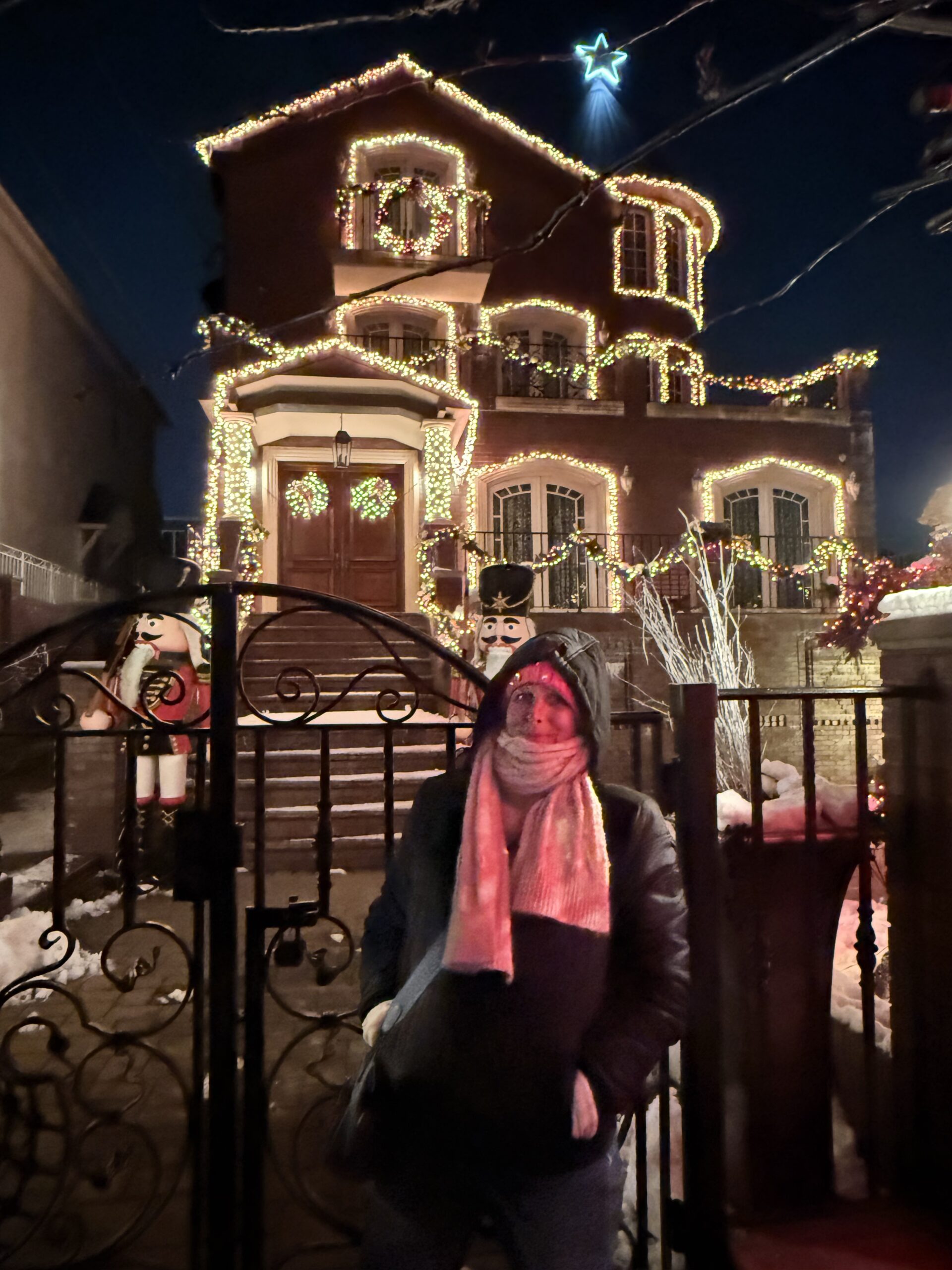 Brooklyn, New York — a woman is standing in front of a house decorated for christmas