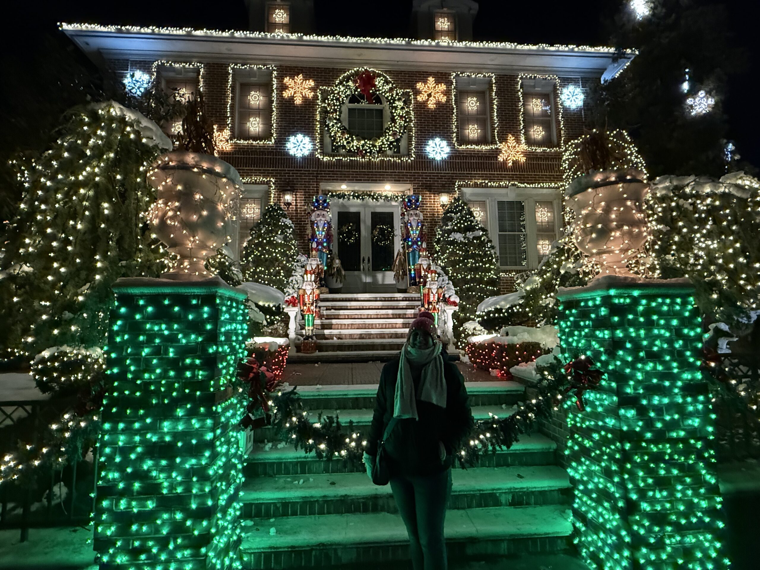 Brooklyn, New York — a woman standing in front of a house with christmas lights