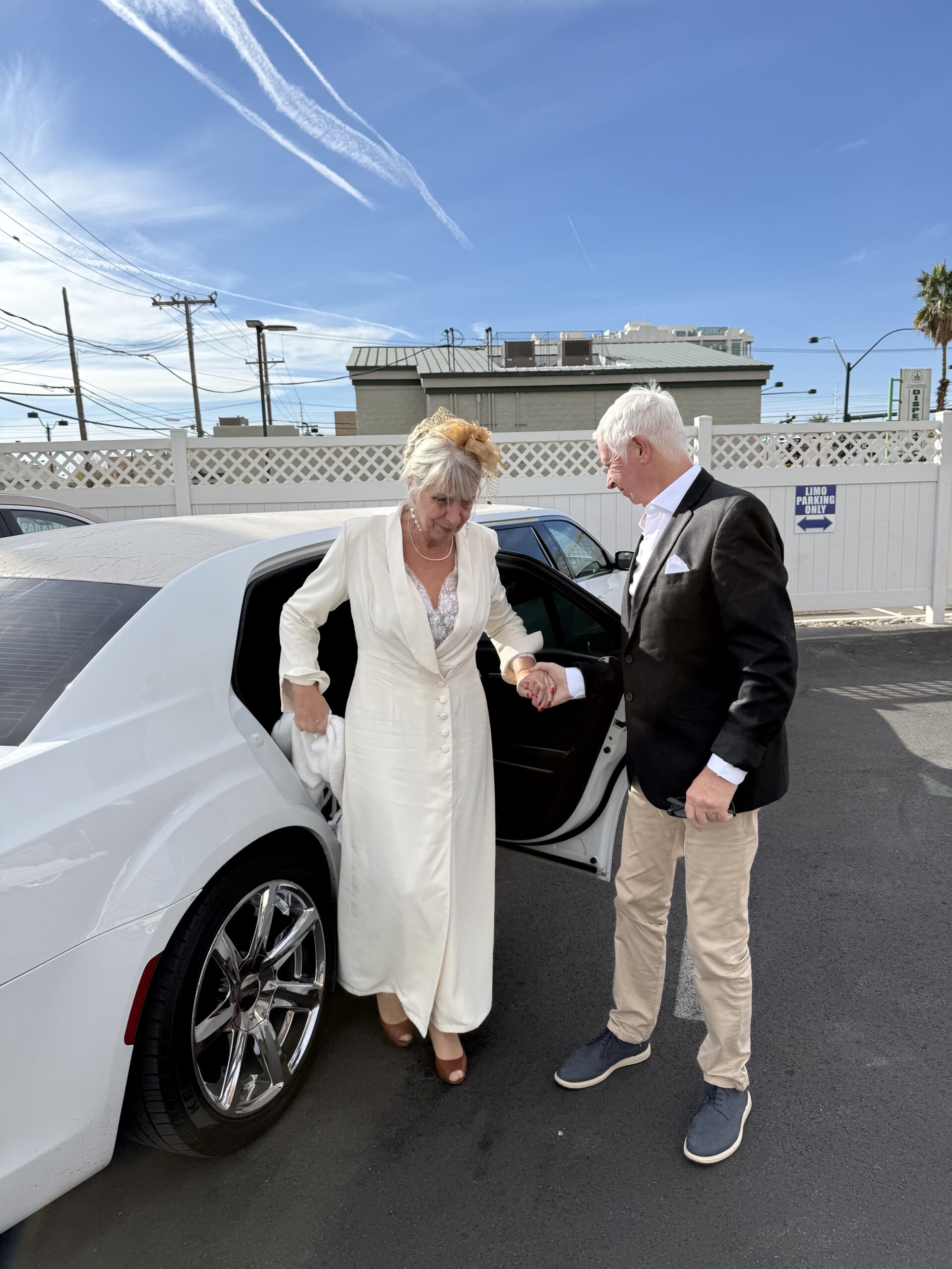 Downtown Las Vegas, Las Vegas — un homme et une femme debout près d'une voiture blanche