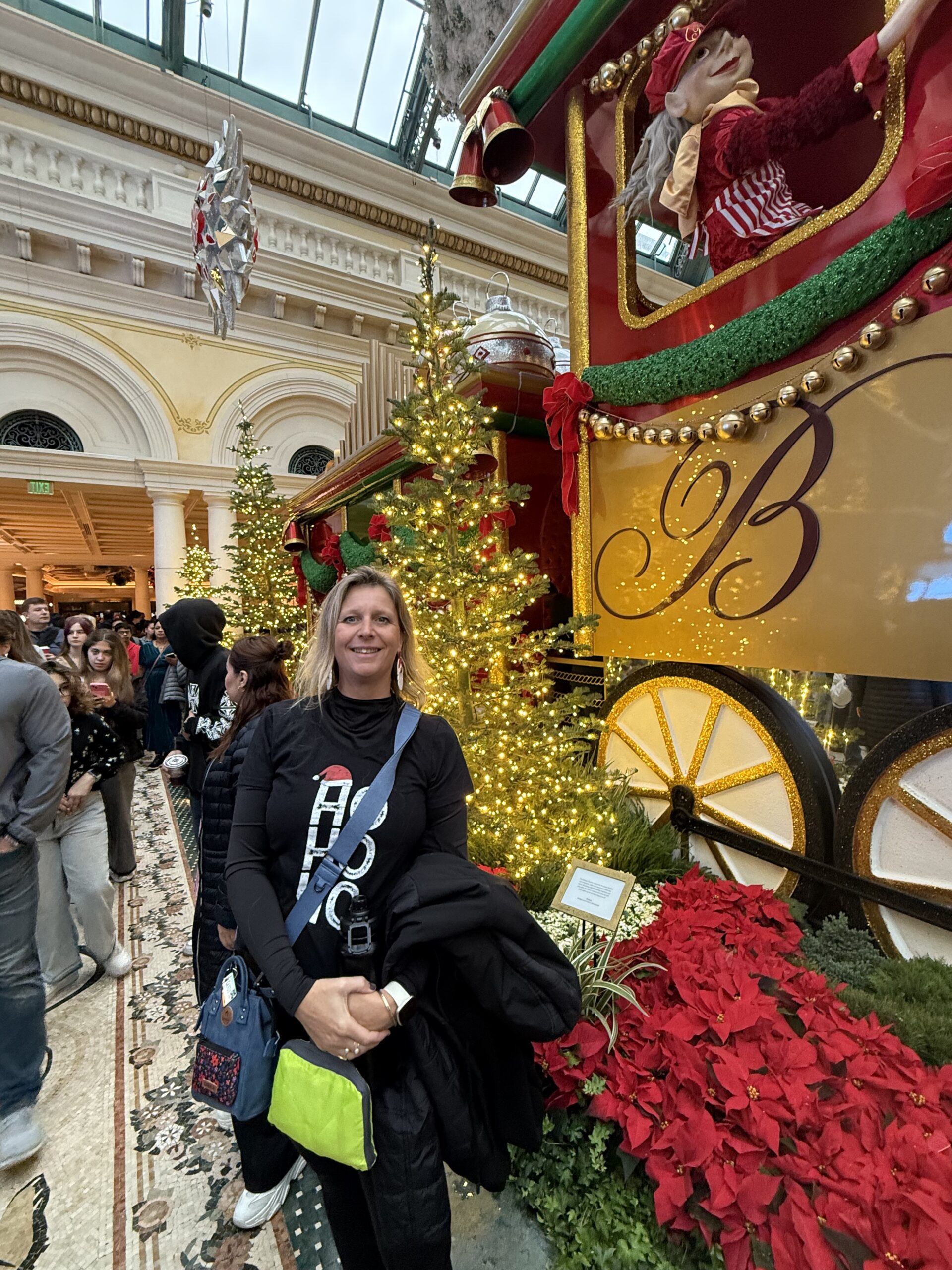 Midtown UNLV, Paradise — une femme debout devant un sapin de Noël