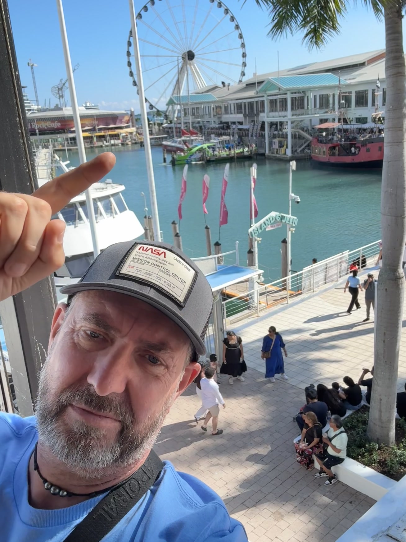 Miami — un homme en chemise bleue et chapeau pointant du doigt la caméra