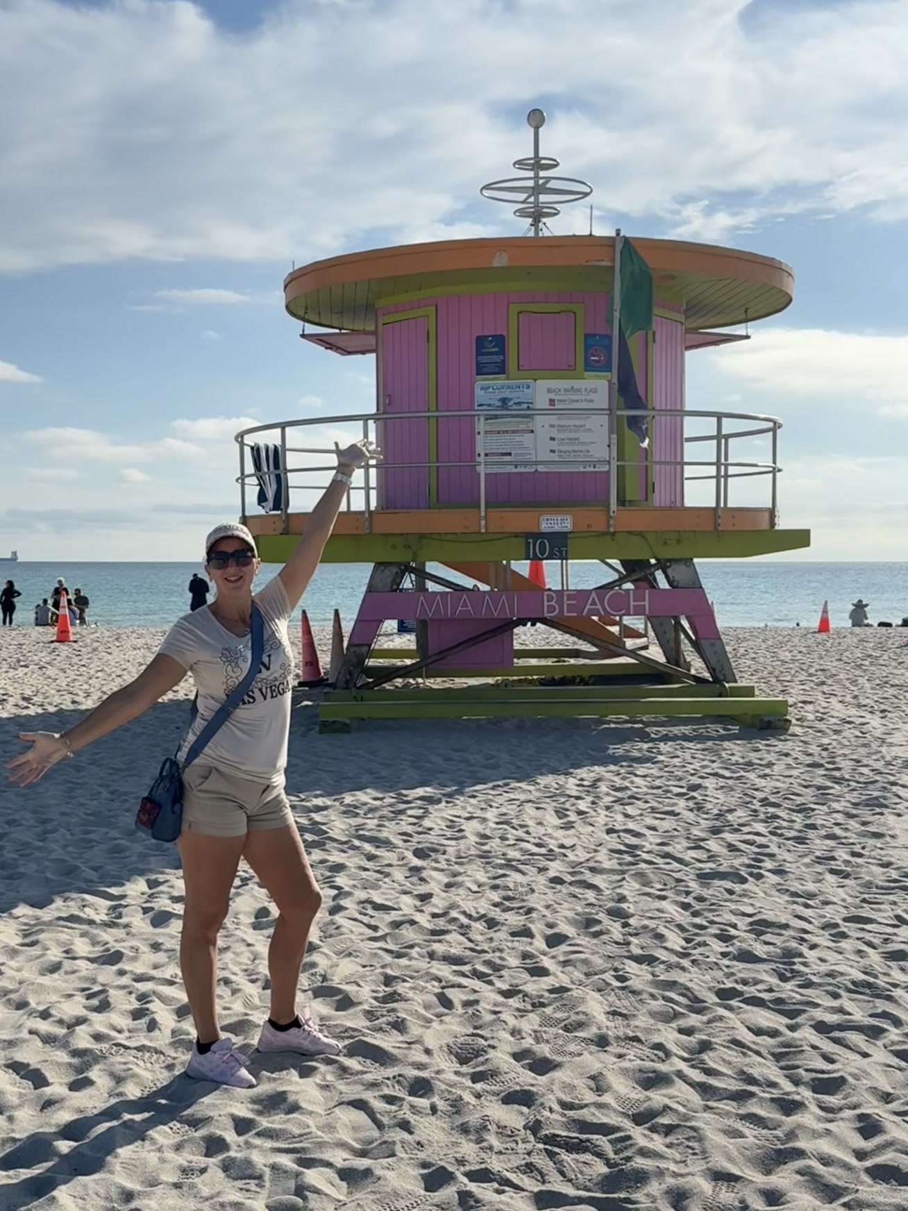 Miami — une femme debout sur la plage, les bras levés