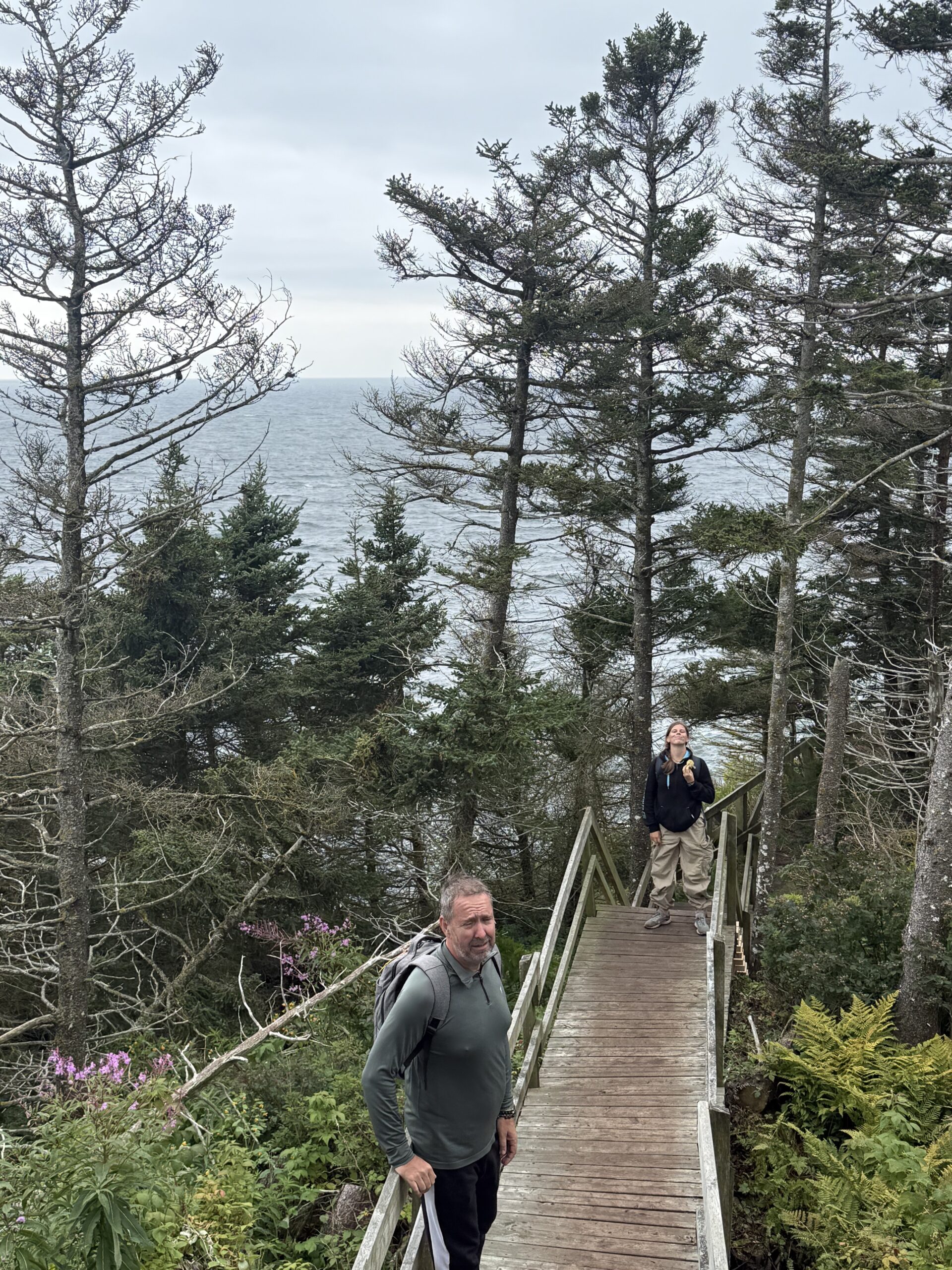 a man walking on a wooden bridge over a lake, Percé, Québec, Canada