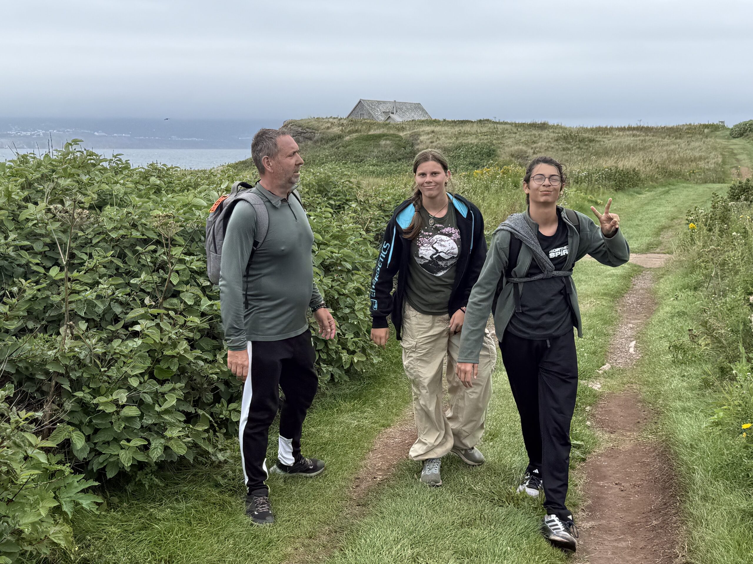two people walking on a path through a field, Percé, Québec, Canada