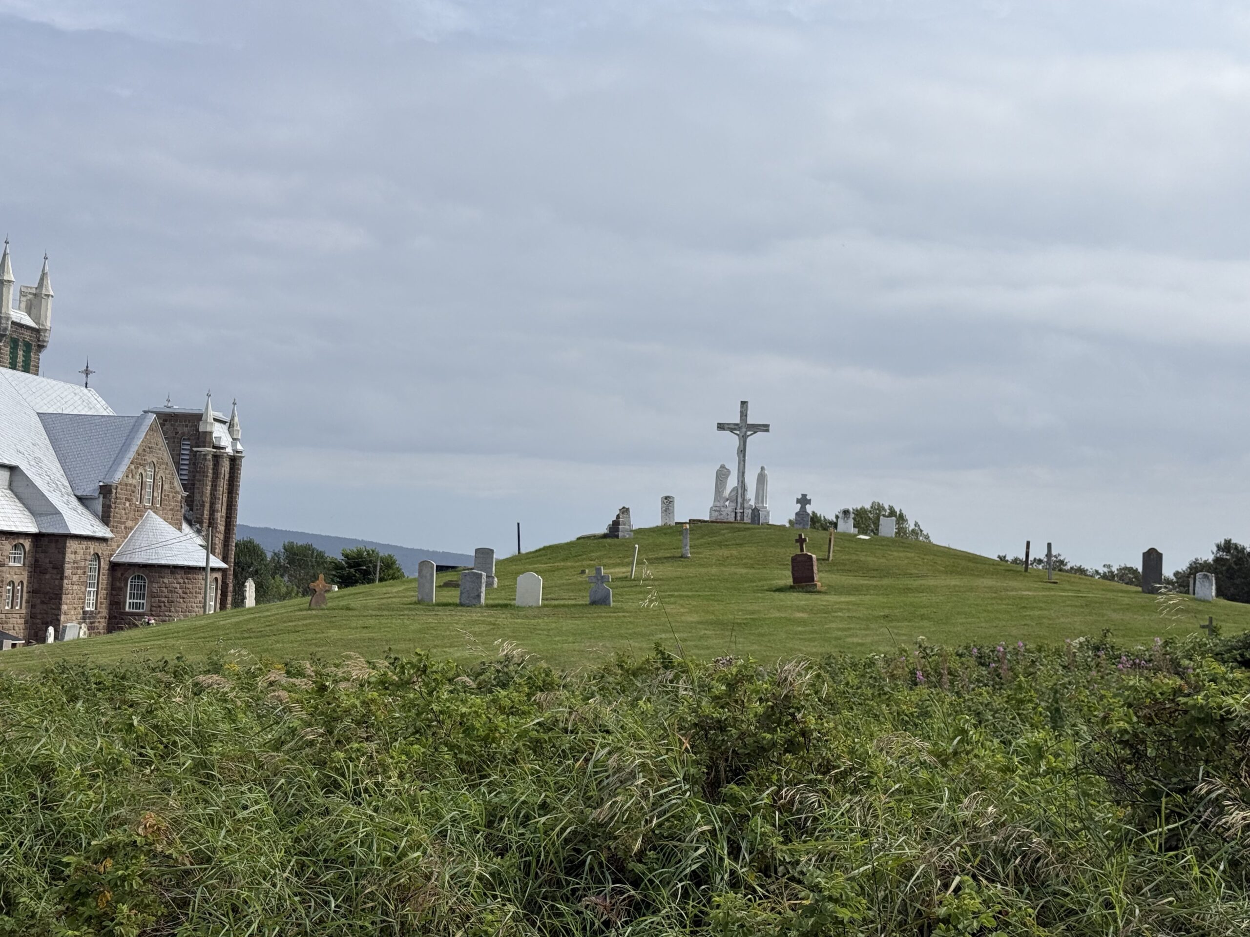 a hill with a church and a cross on top, Percé, Québec, Canada