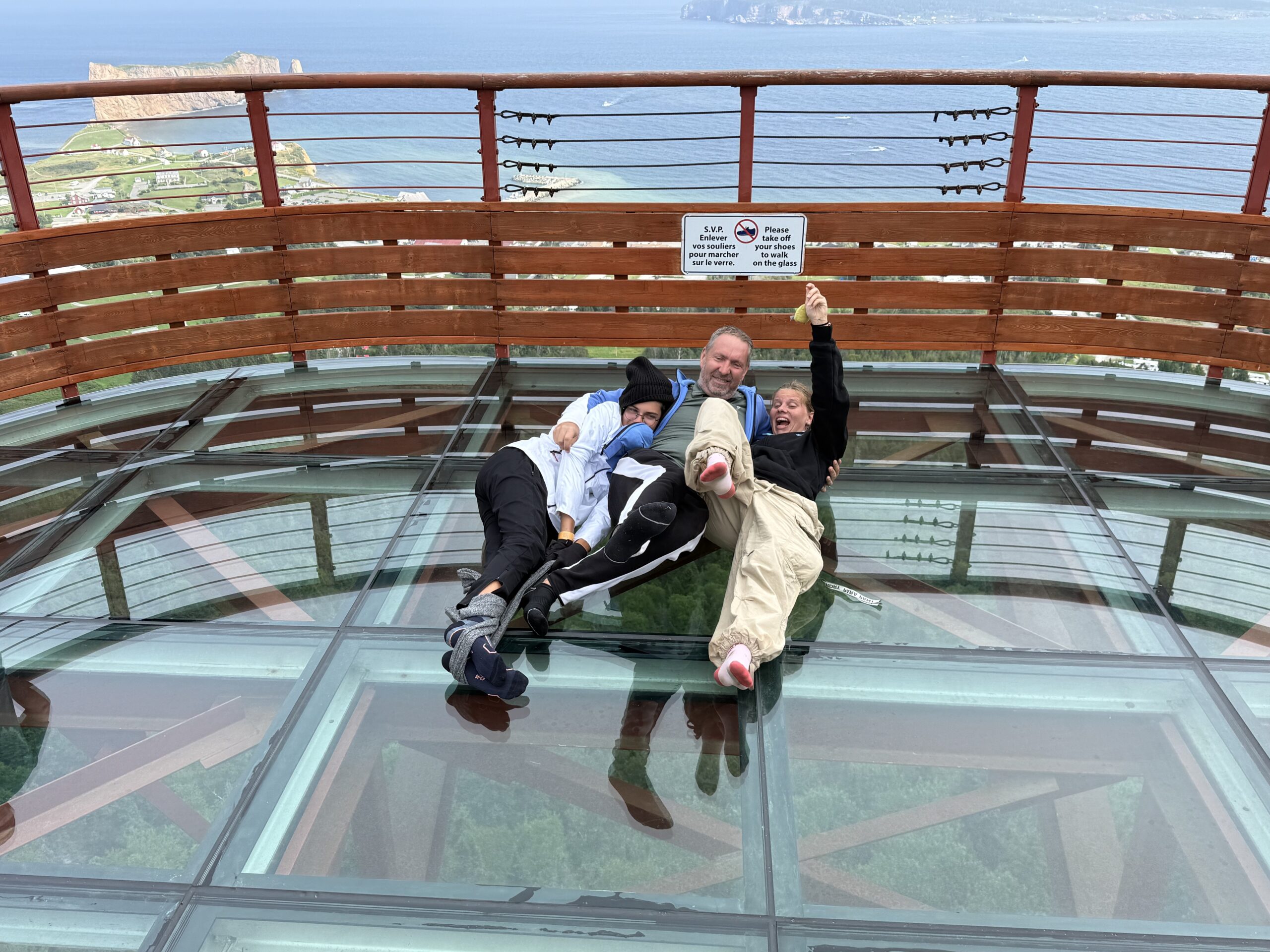 a man and woman sitting on a glass floor, Percé, Québec, Canada