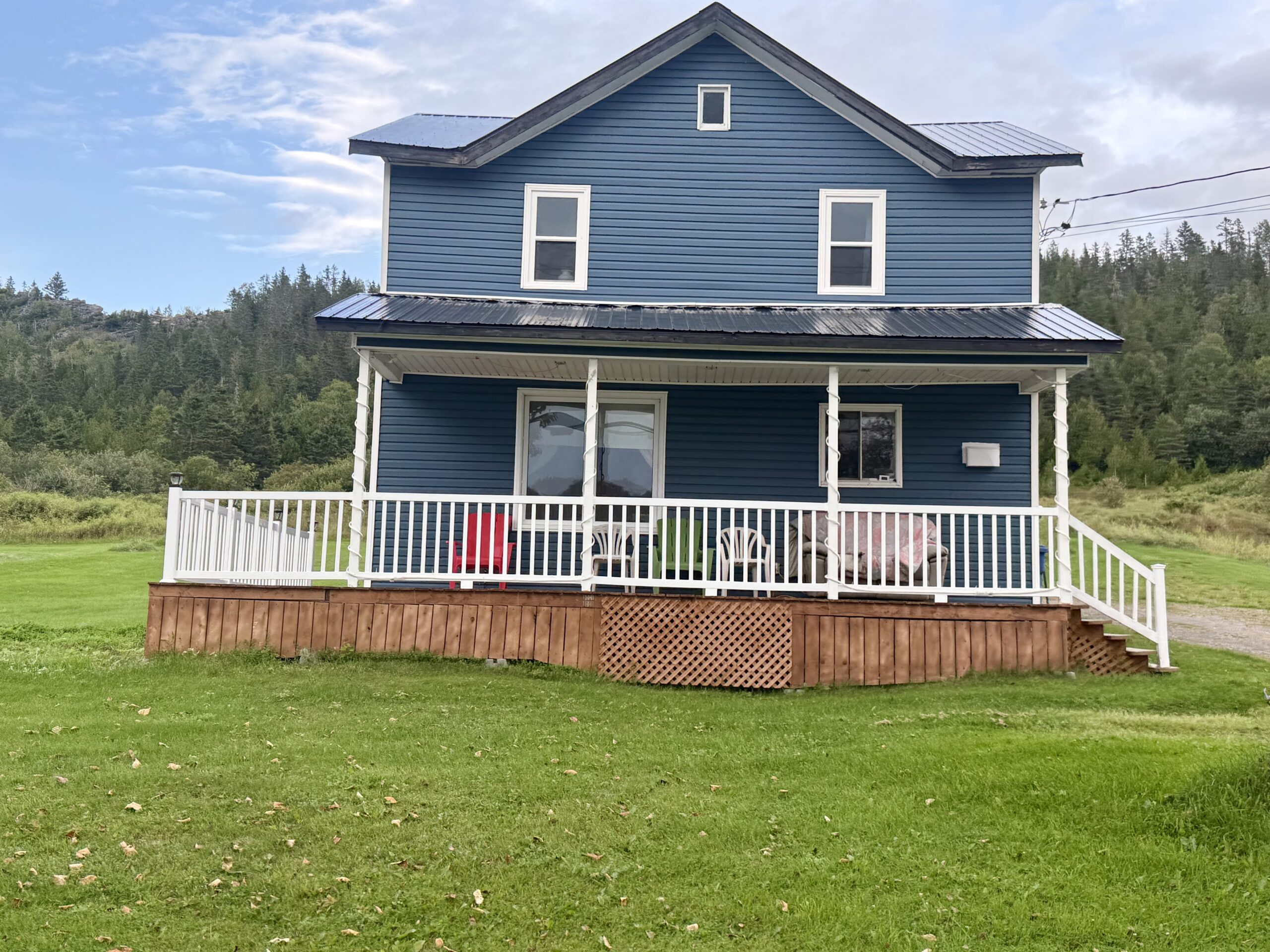 a blue house with a white porch and a white fence, Port-Daniel-Gascons, Québec, Canada