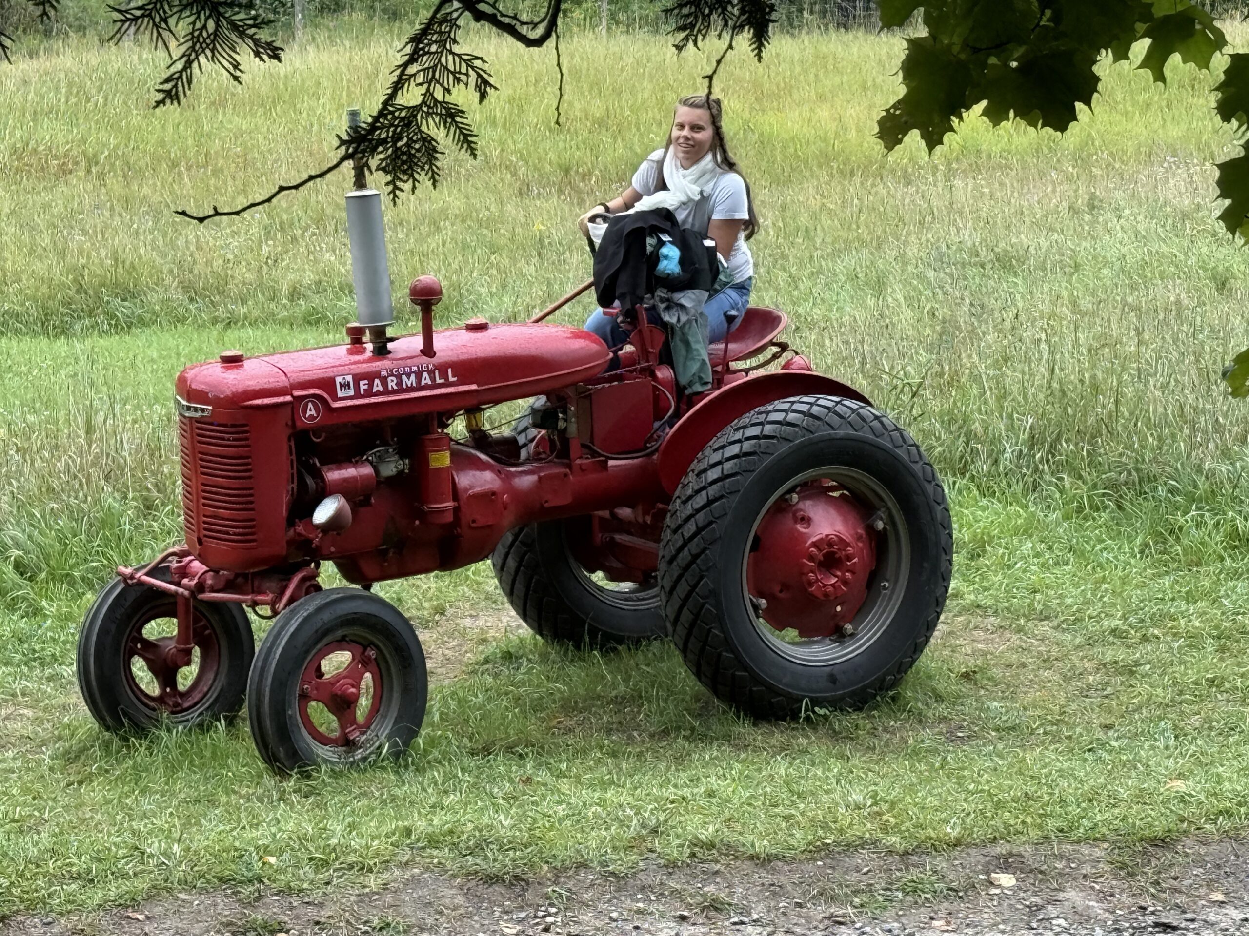 a young boy is riding on a red tractor, Papineauville, Québec, Canada