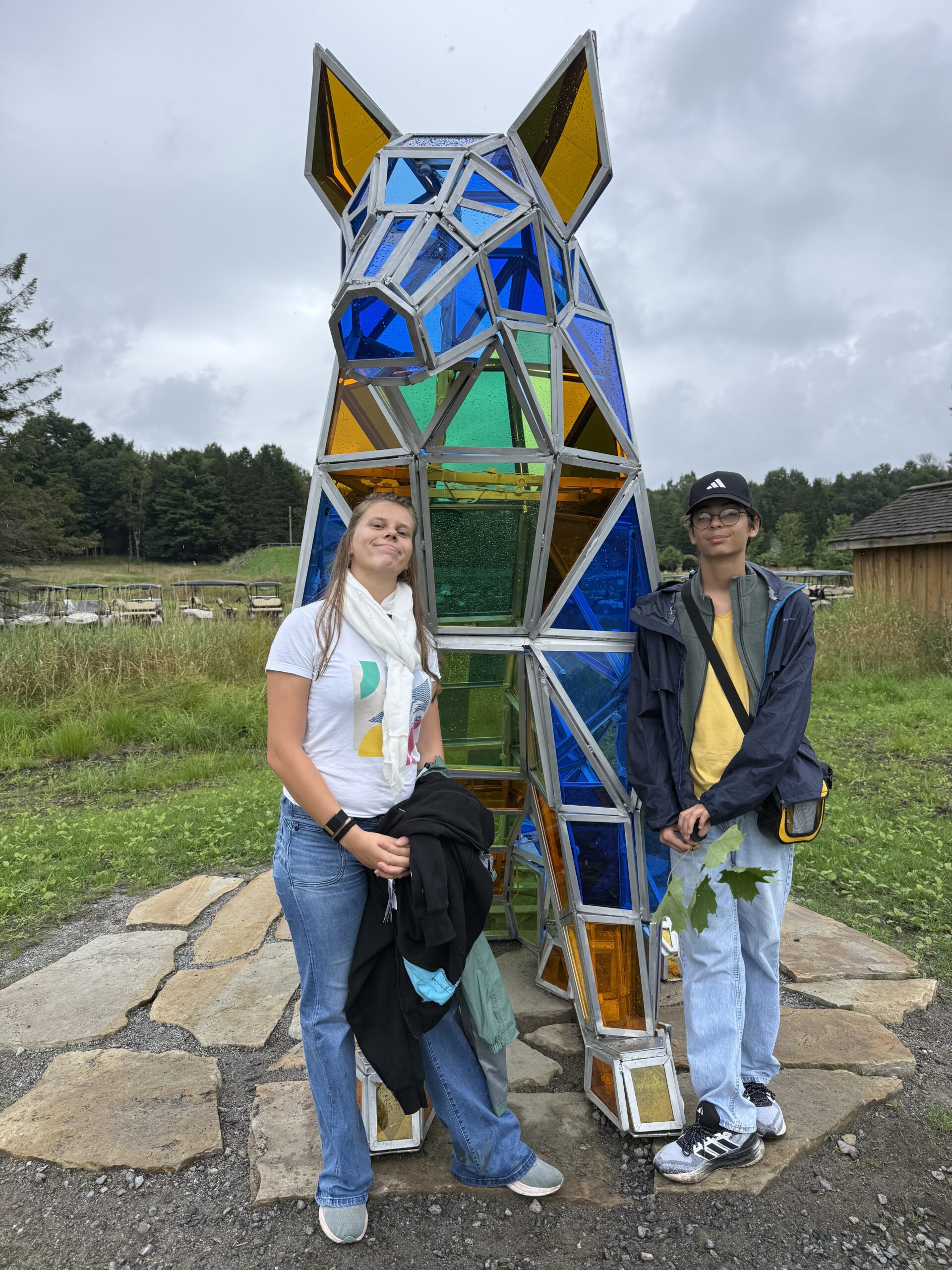 a couple of people standing next to a dog sculpture, Papineauville, Québec, Canada