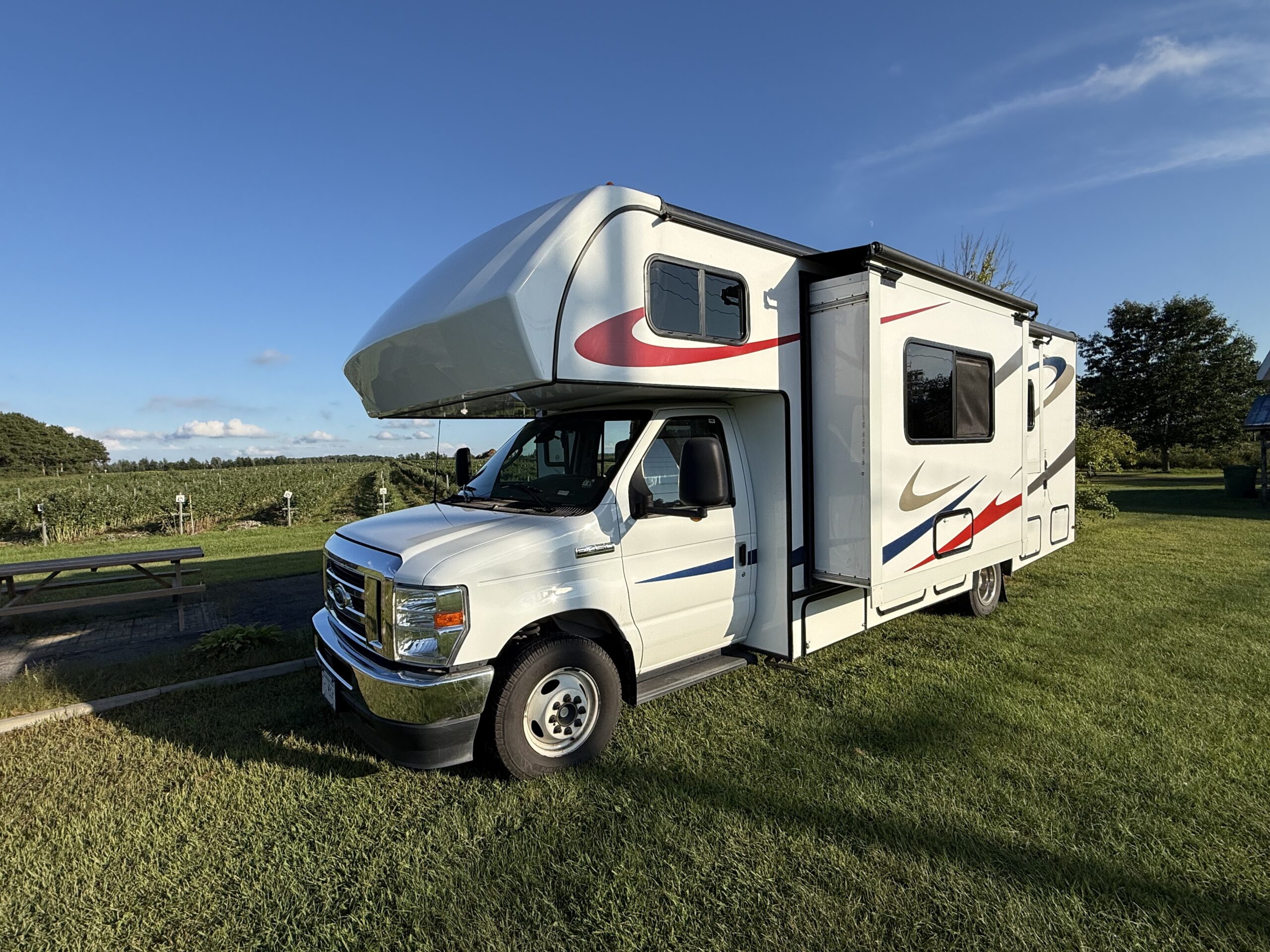 a white rv parked in a grassy field, Lavaltrie, Québec, Canada