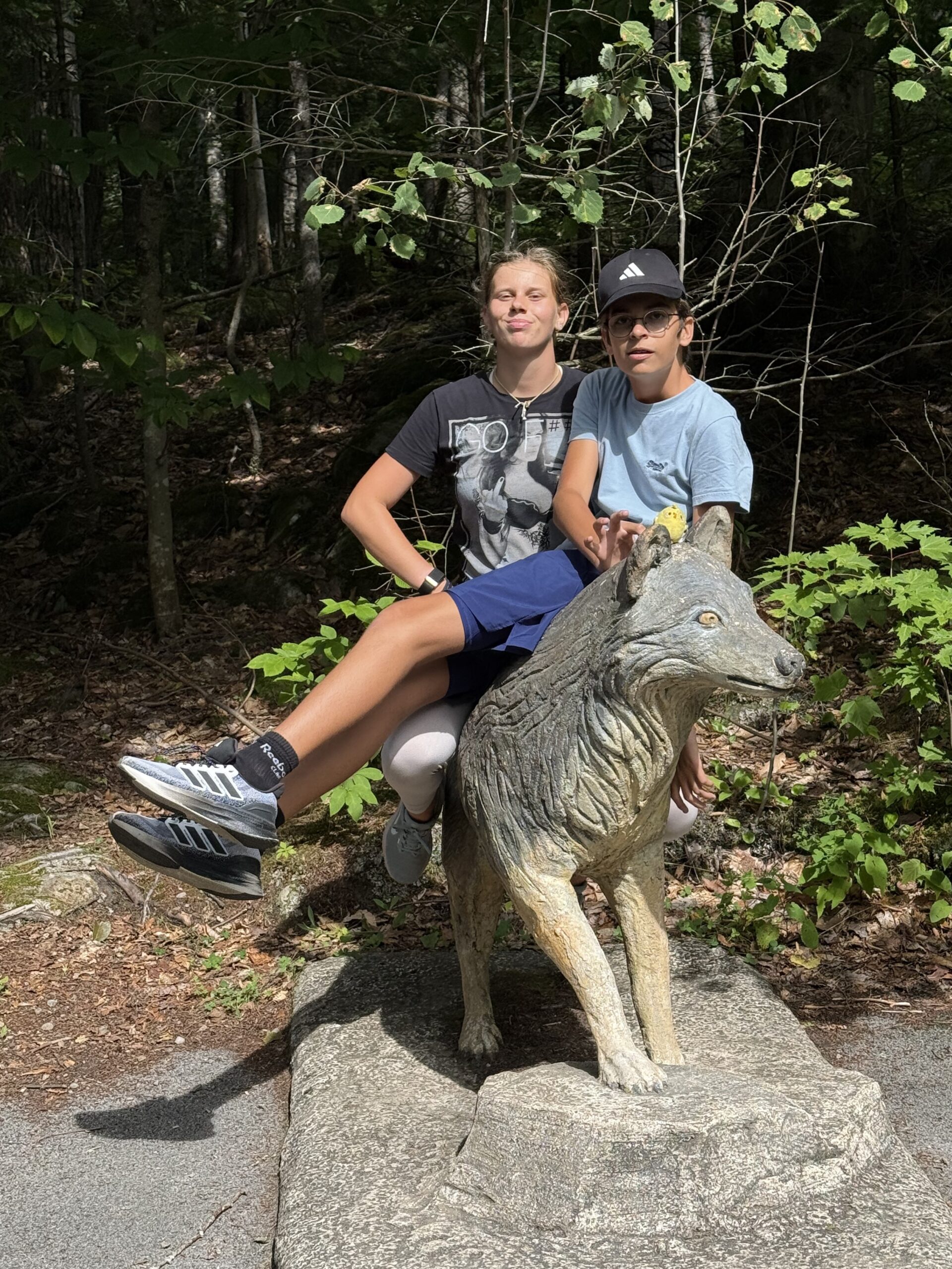 un homme et une femme assis sur une statue de loup, Saint-Joachim, Québec, Canada