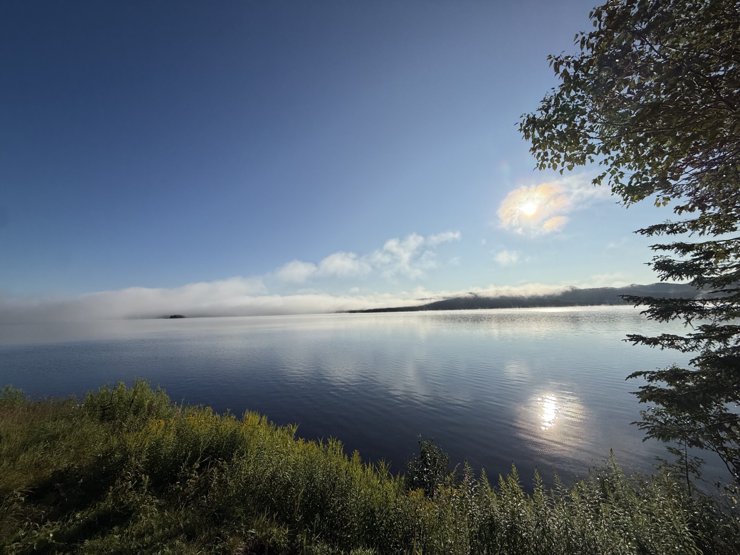 un lac avec quelques arbres et quelques nuages, Lac-Jacques-Cartier, Québec, Canada