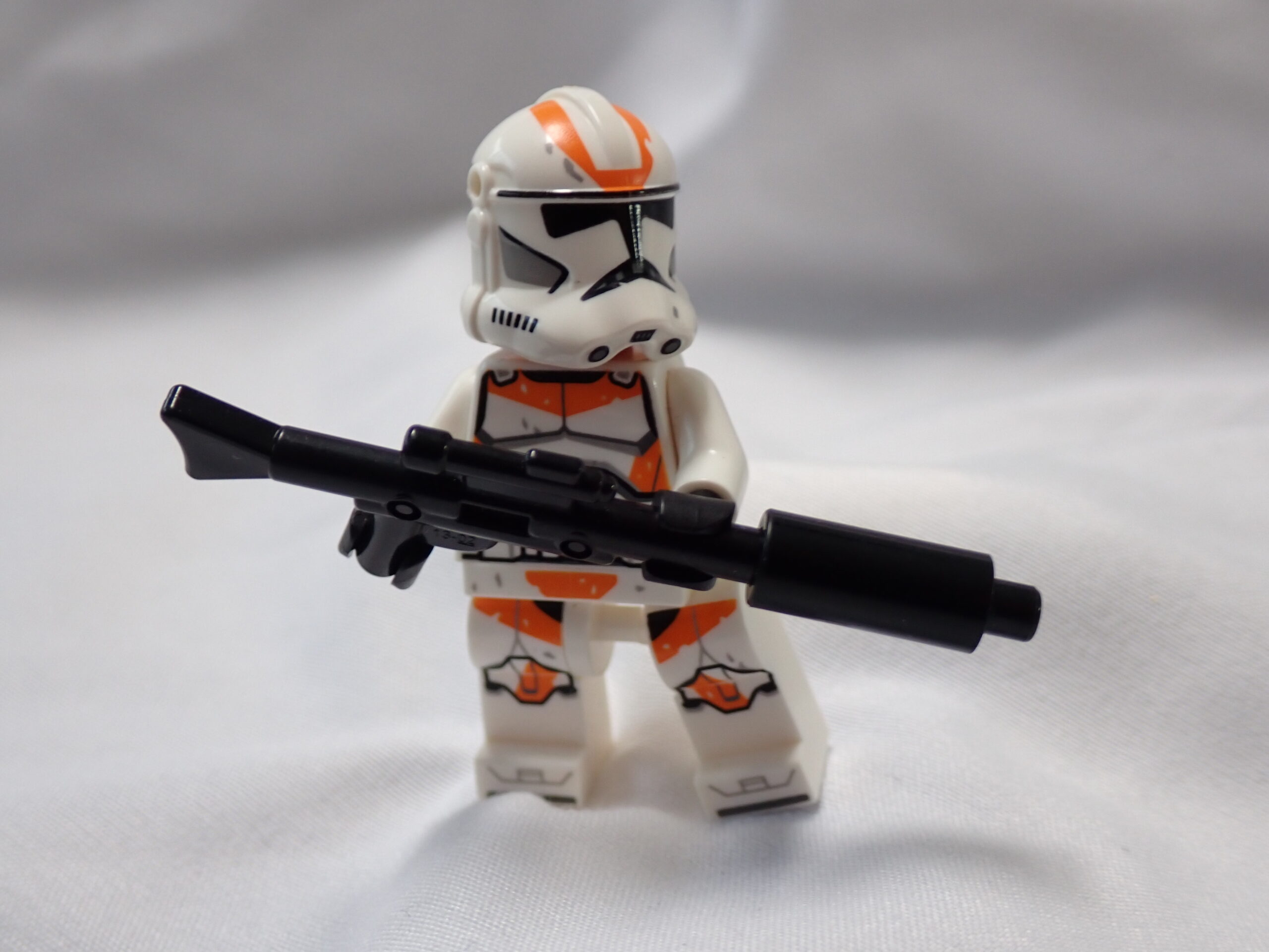une figurine Lego tenant un fusil sur un fond blanc