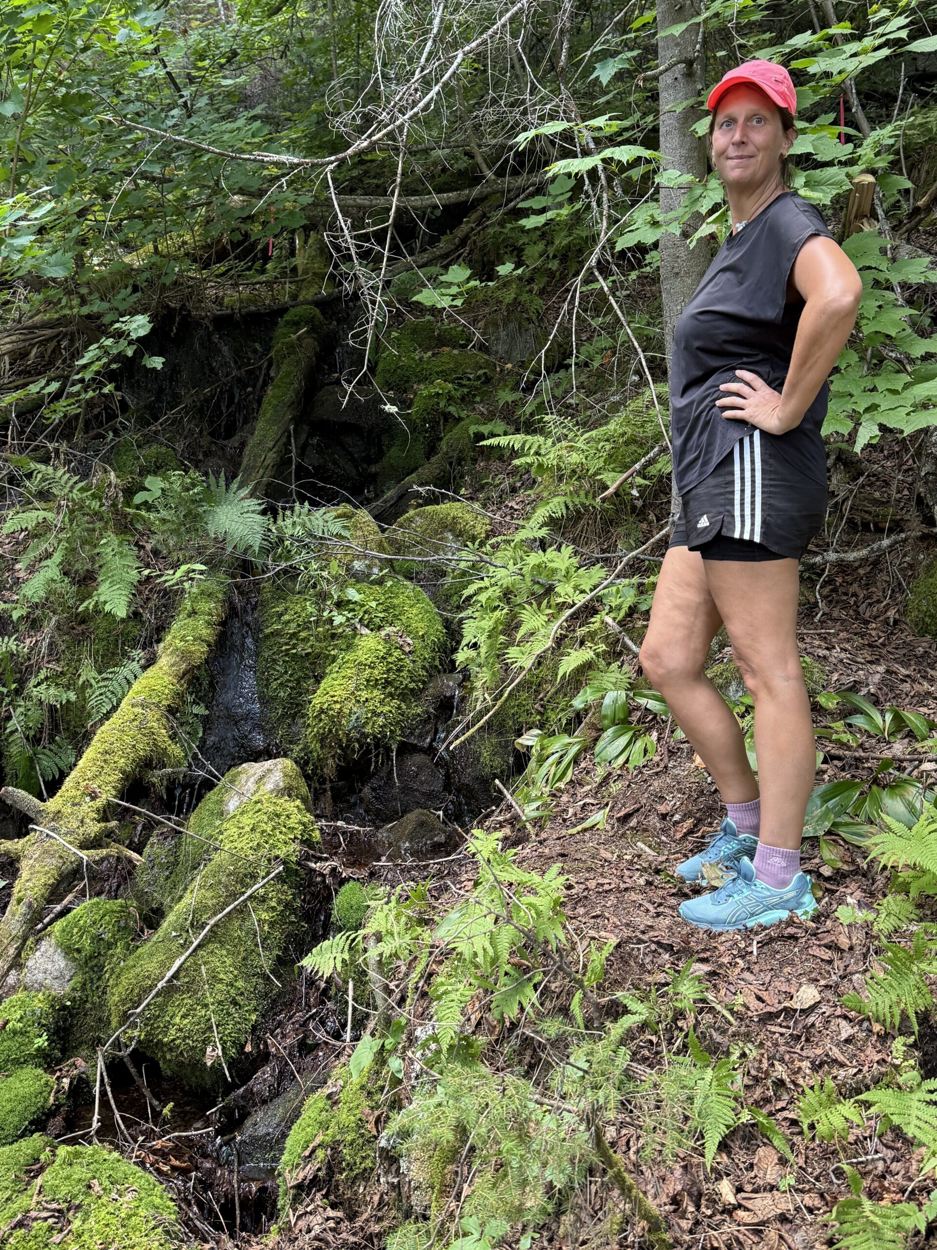 Une femme debout dans les bois avec un chapeau rouge, Rivière-Éternité, Québec, Canada