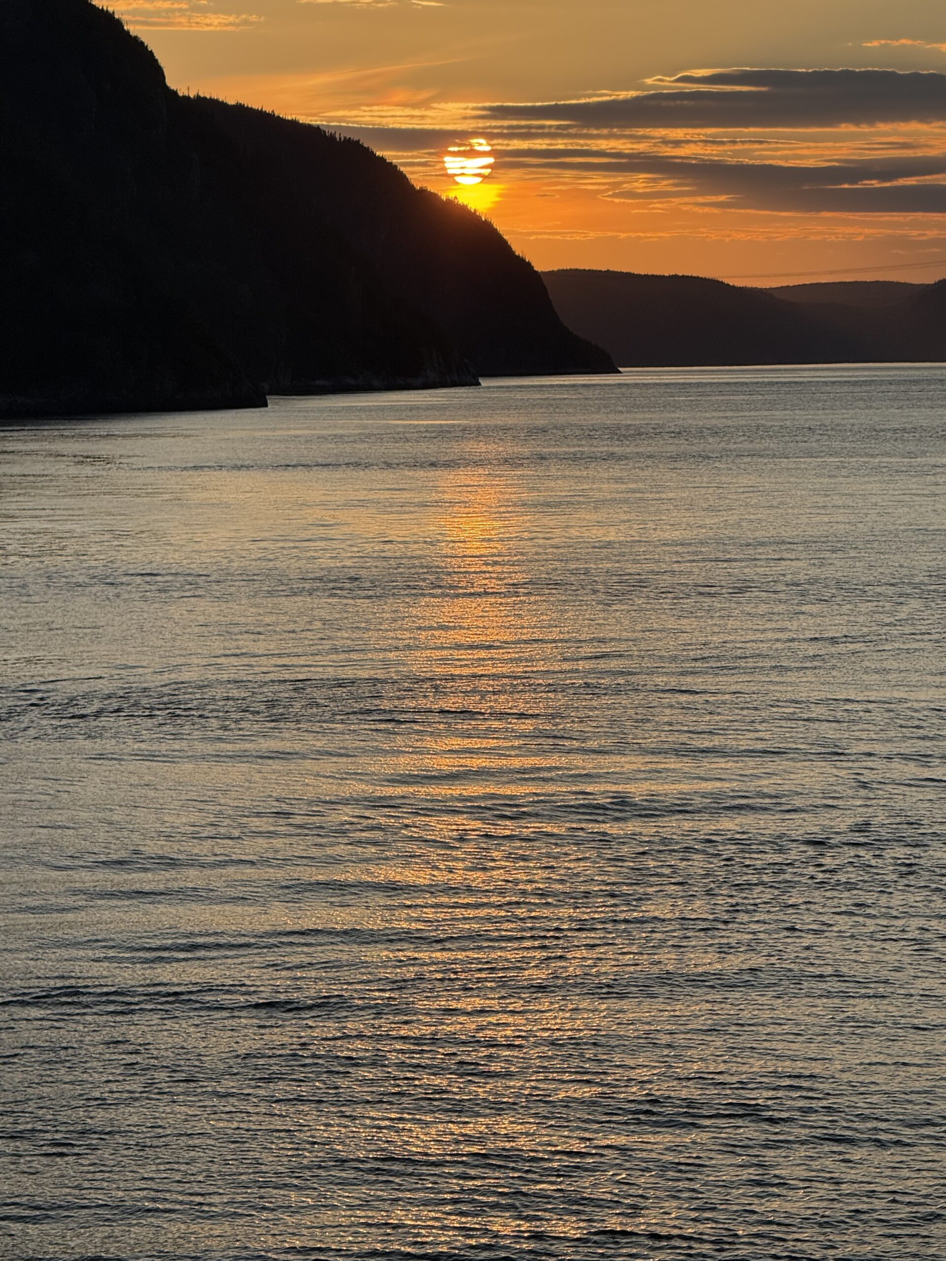 Un bateau est sur l'eau au coucher du soleil, Baie-Sainte-Catherine, Québec, Canada