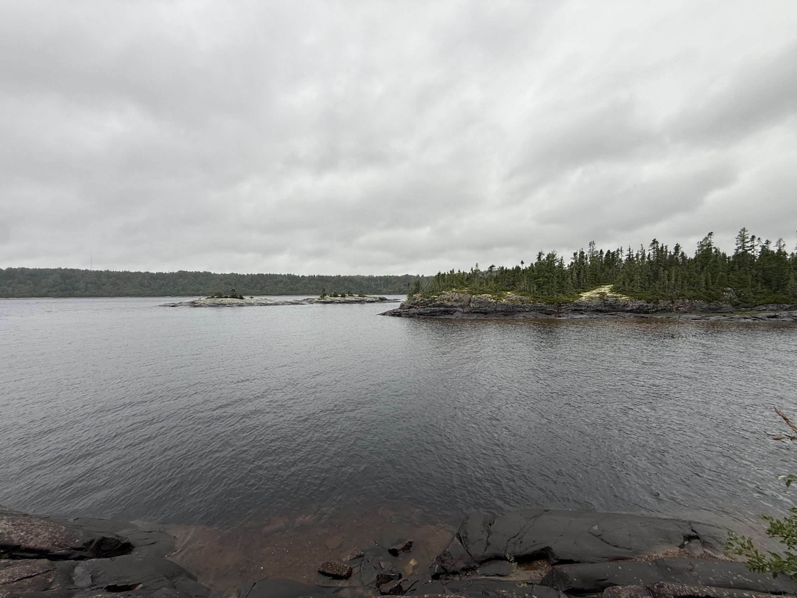 une étendue d'eau entourée d'arbres et de rochers, Baie-Comeau, Québec, Canada