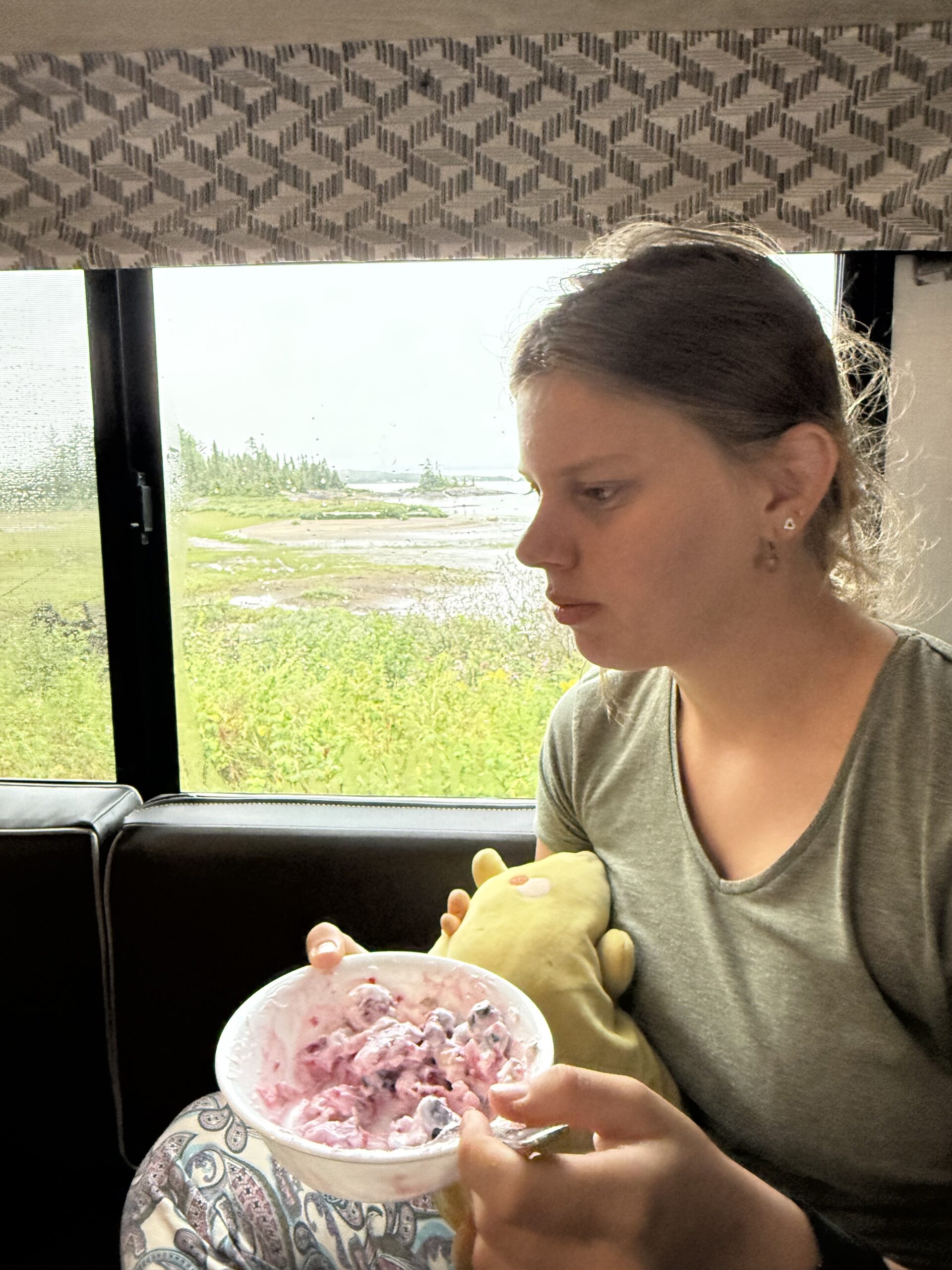une femme assise dans un bus mangeant un bol de nourriture, Baie-Comeau, Québec, Canada