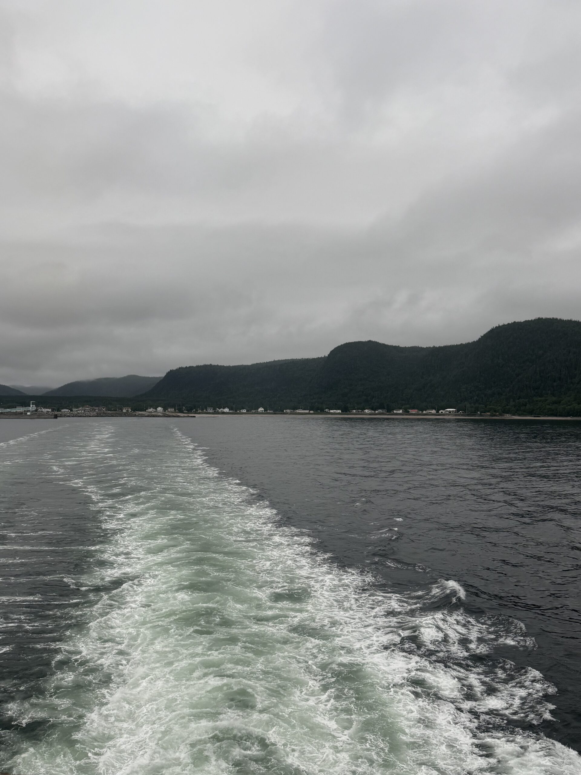 un bateau naviguant sur l'océan avec des montagnes en arrière-plan, Québec, Canada