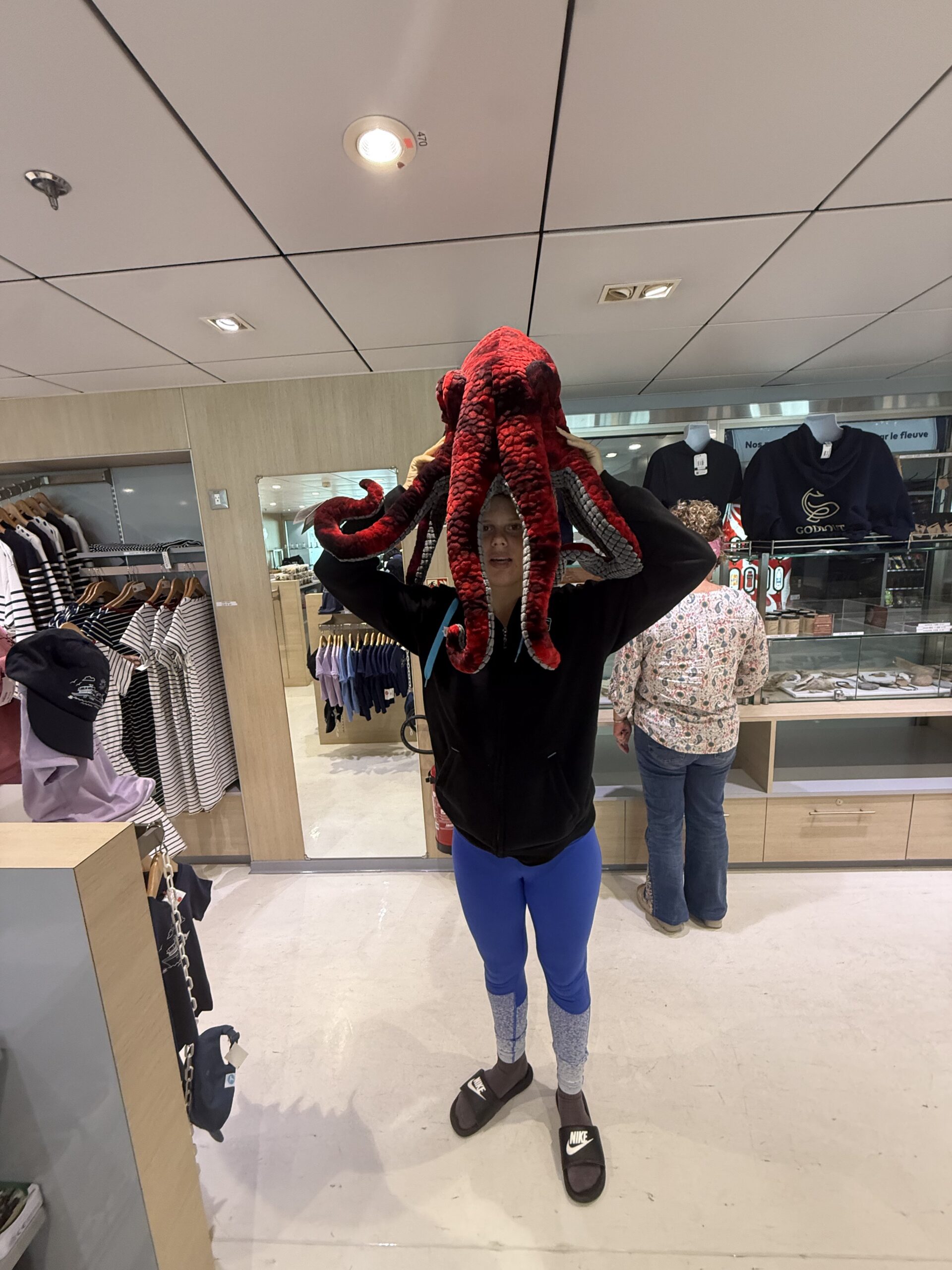 une femme tenant une peluche dans un magasin