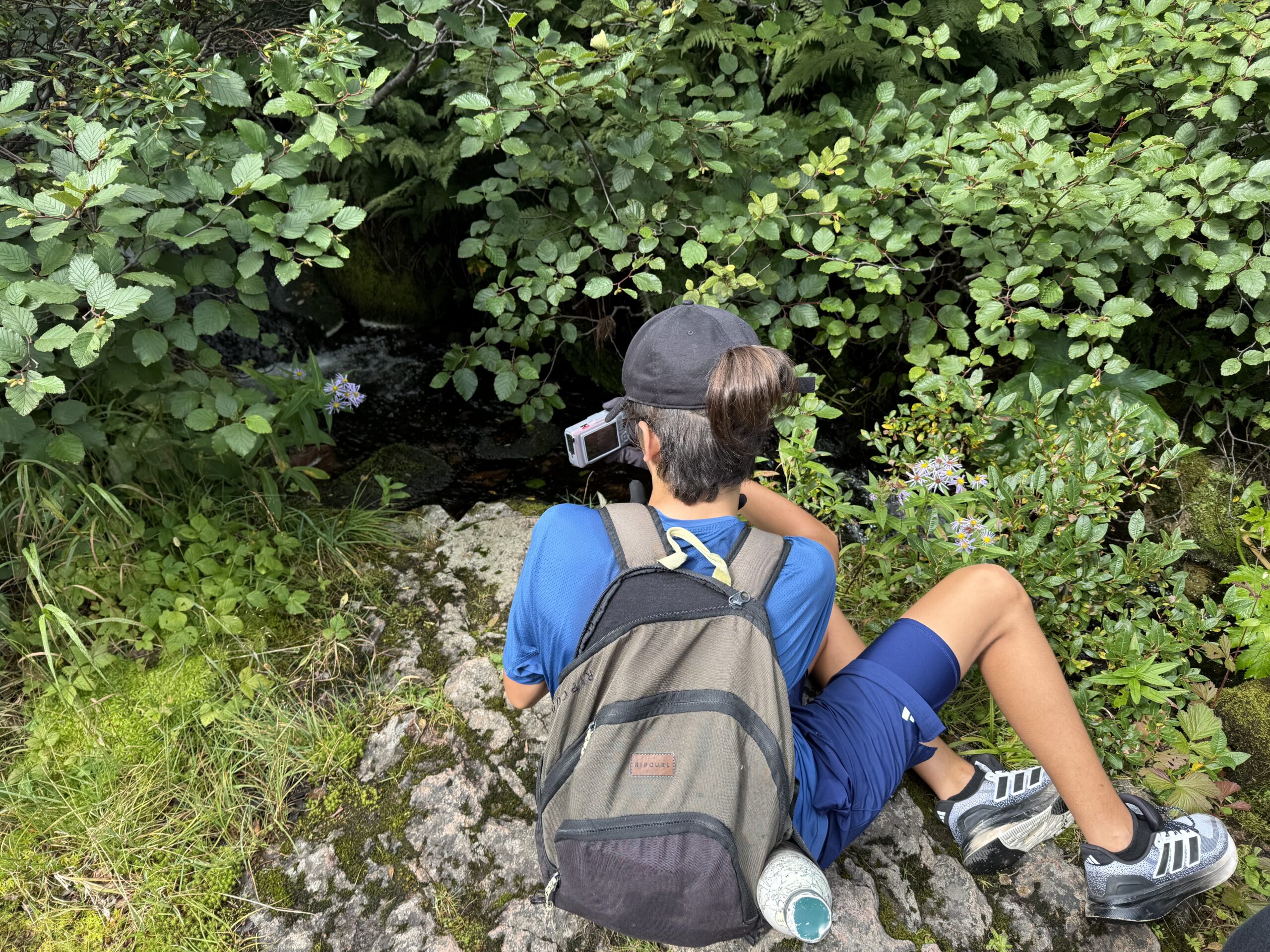 une personne assise sur un rocher avec un sac à dos, Mont-Albert, Québec, Canada