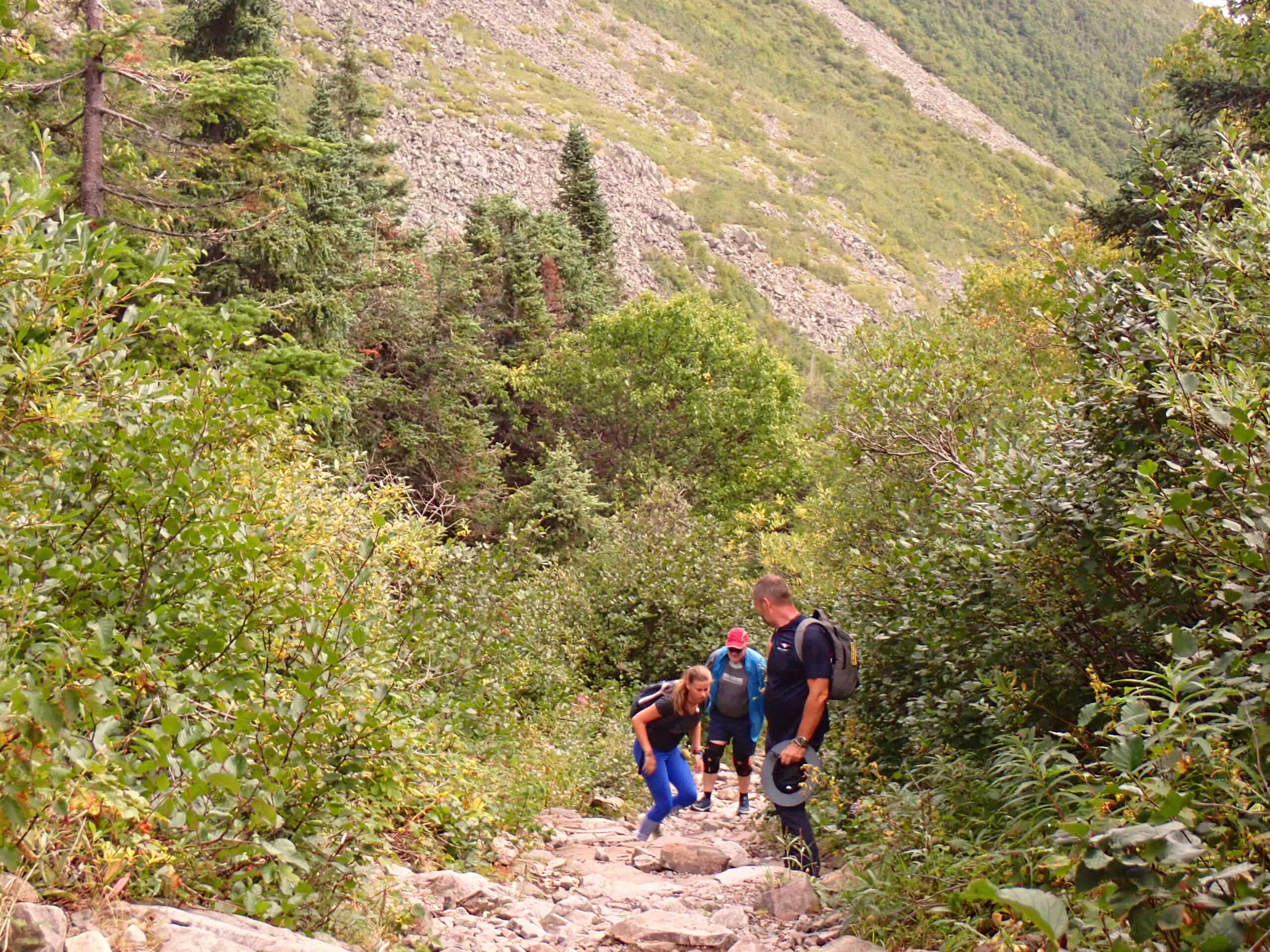 un homme et une femme faisant une randonnée sur un sentier rocheux