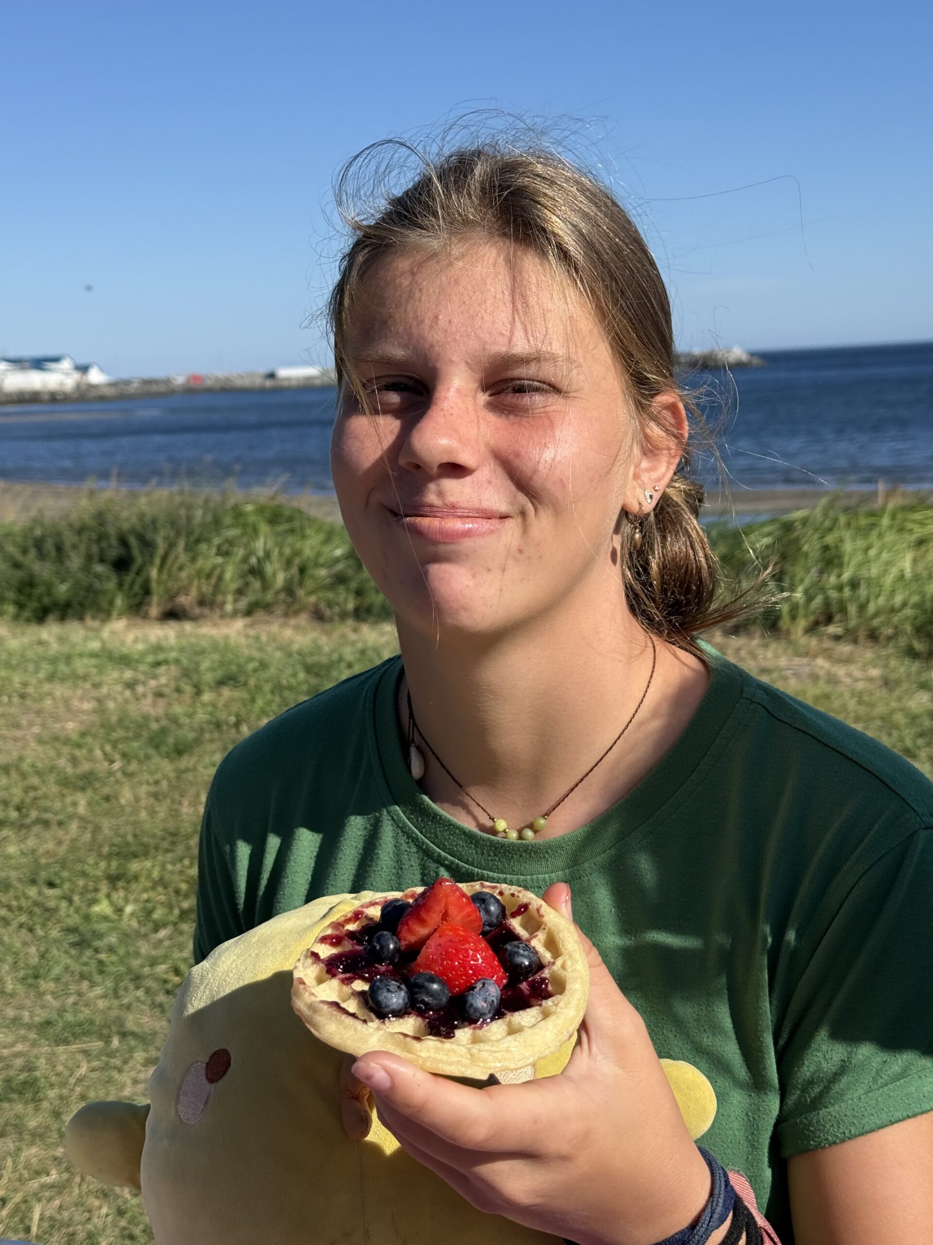 a woman holding a sandwich with fruit on it, Saint-Maxime-du-Mont-Louis, Québec, Canada