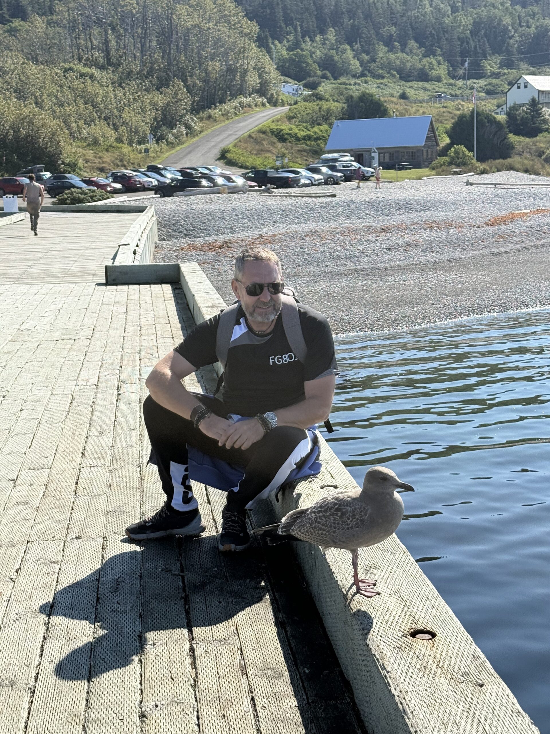 un homme agenouillé sur un quai avec un oiseau, Québec, Canada