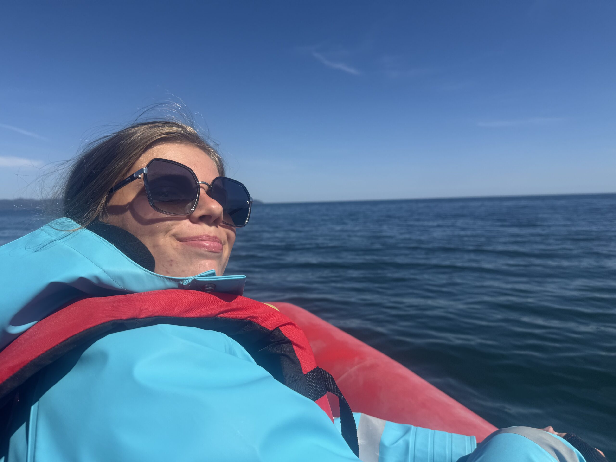 une femme en veste bleue et lunettes de soleil sur un bateau, Gaspé, Québec, Canada