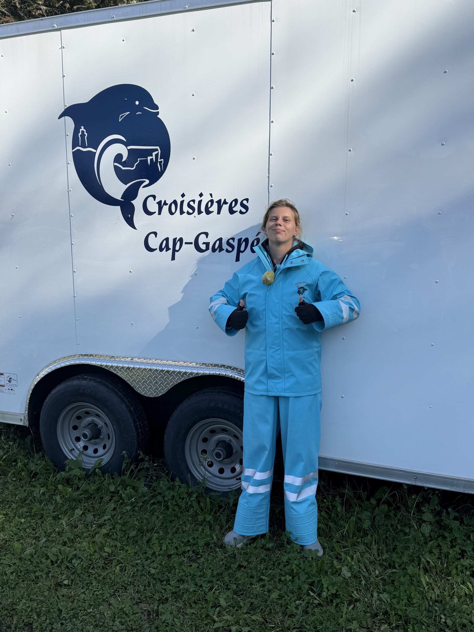 une femme debout à côté d'une remorque avec un logo, Gaspé, Québec, Canada
