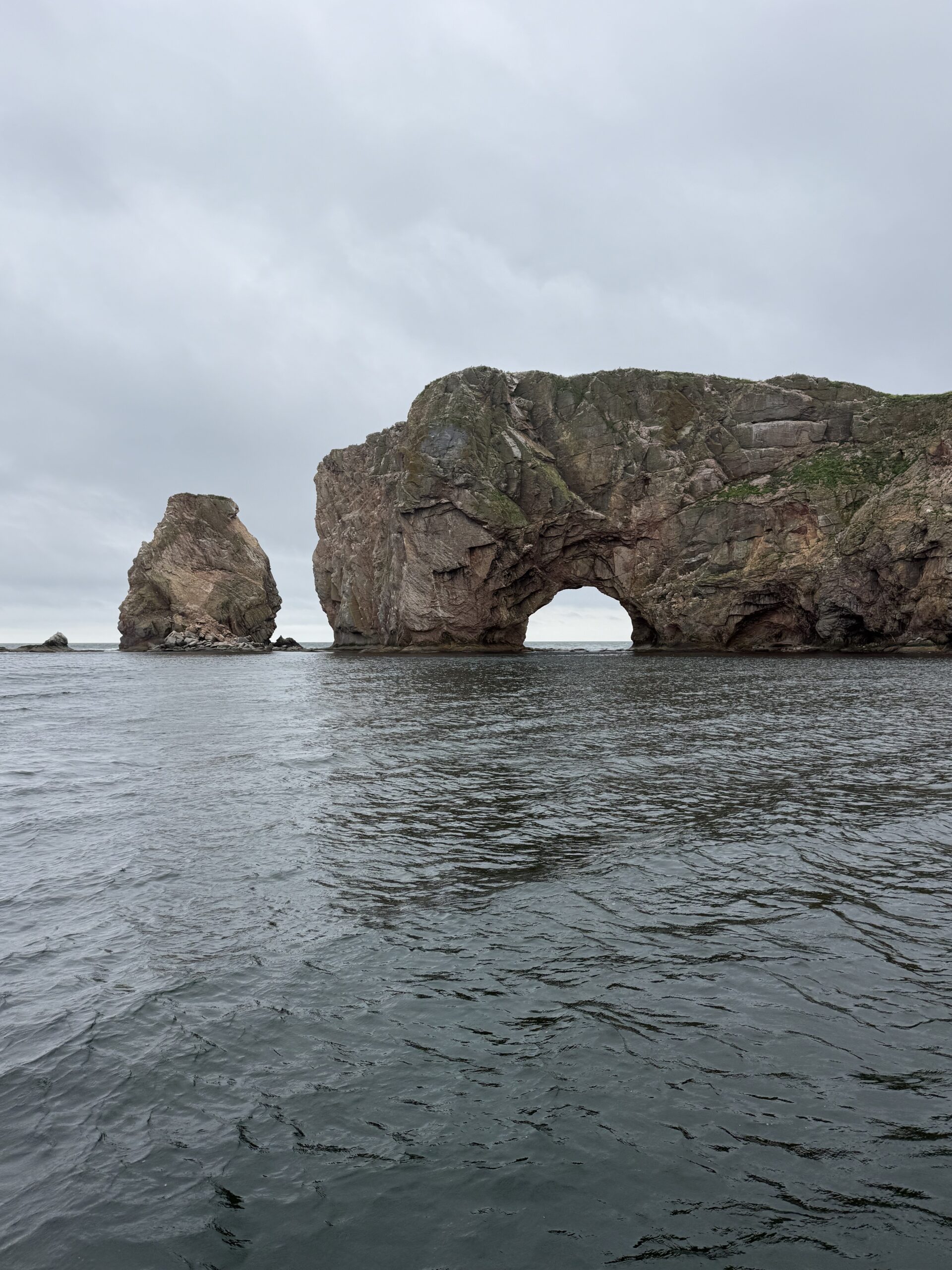 a large rock formation in the water, Québec, Canada