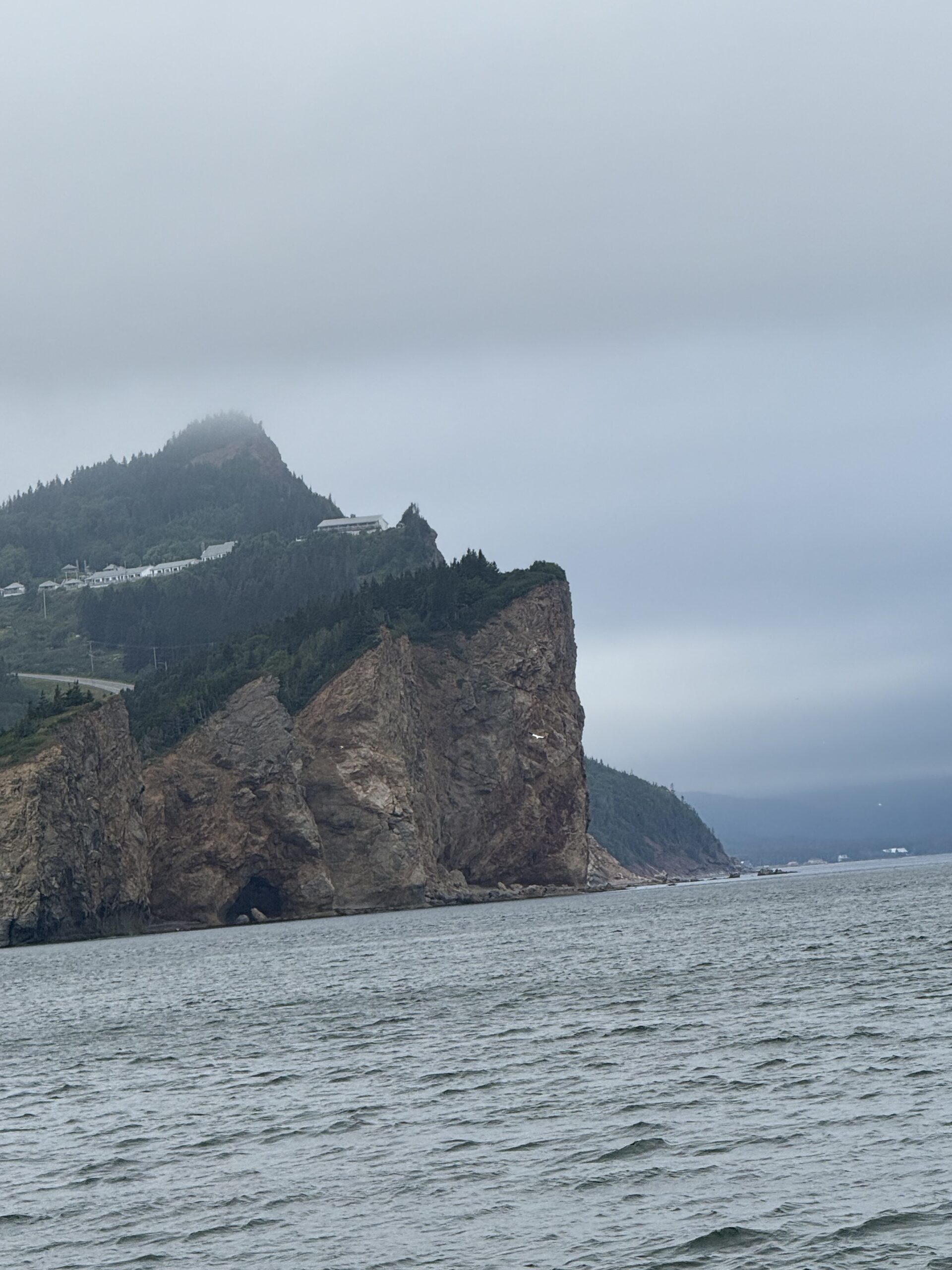 a boat is in the water near a rocky island, Québec, Canada