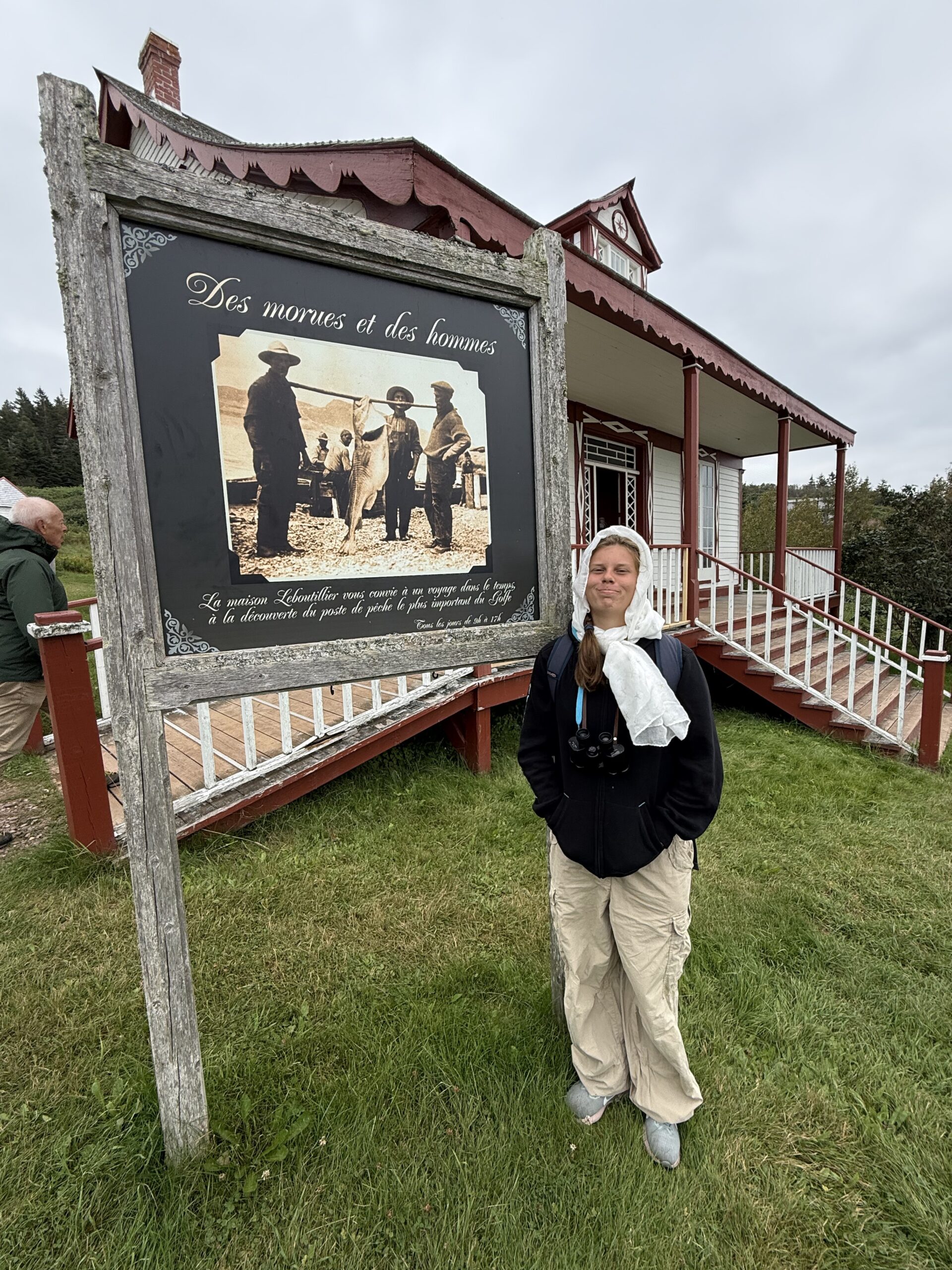 a man standing in front of a sign, Percé, Québec, Canada