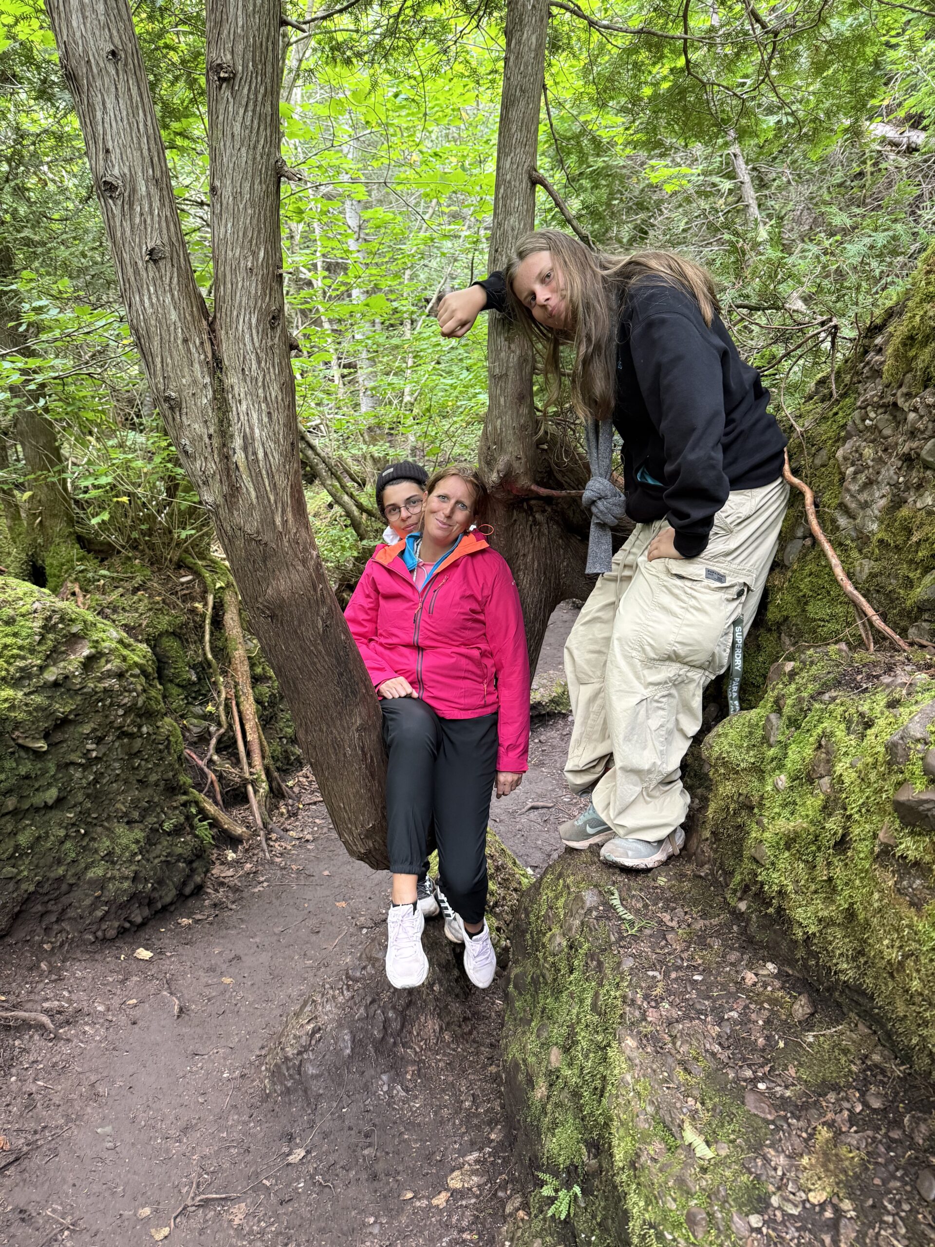a woman and a child are standing in the woods, Percé, Québec, Canada