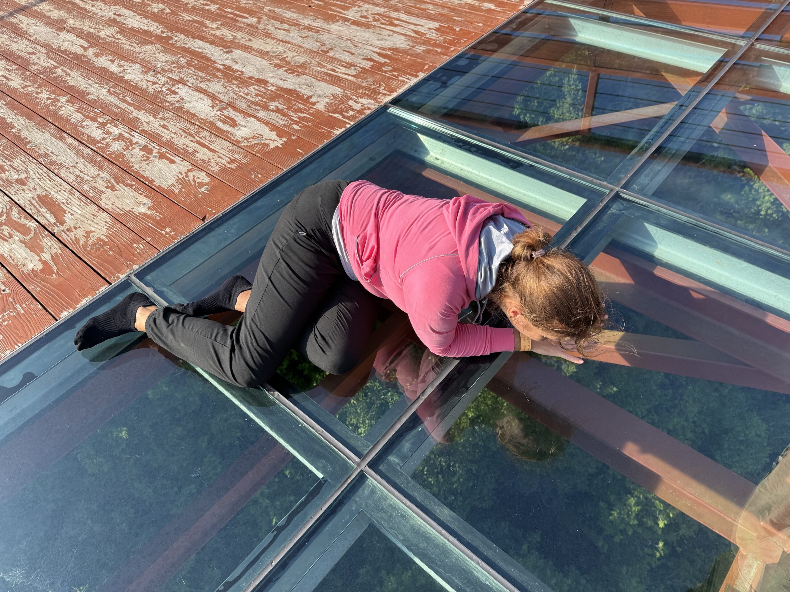 a woman is standing on a glass floor, Percé, Québec, Canada