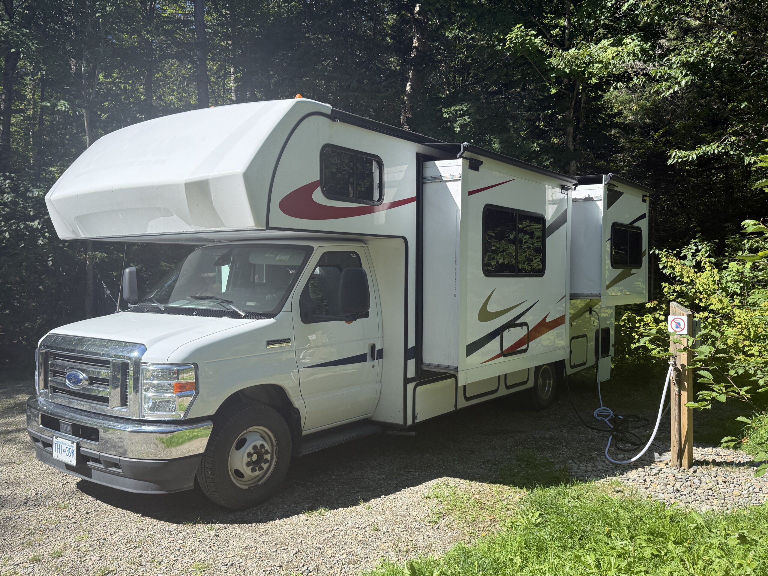 a camper parked in a wooded area, Port-Daniel, Québec, Canada