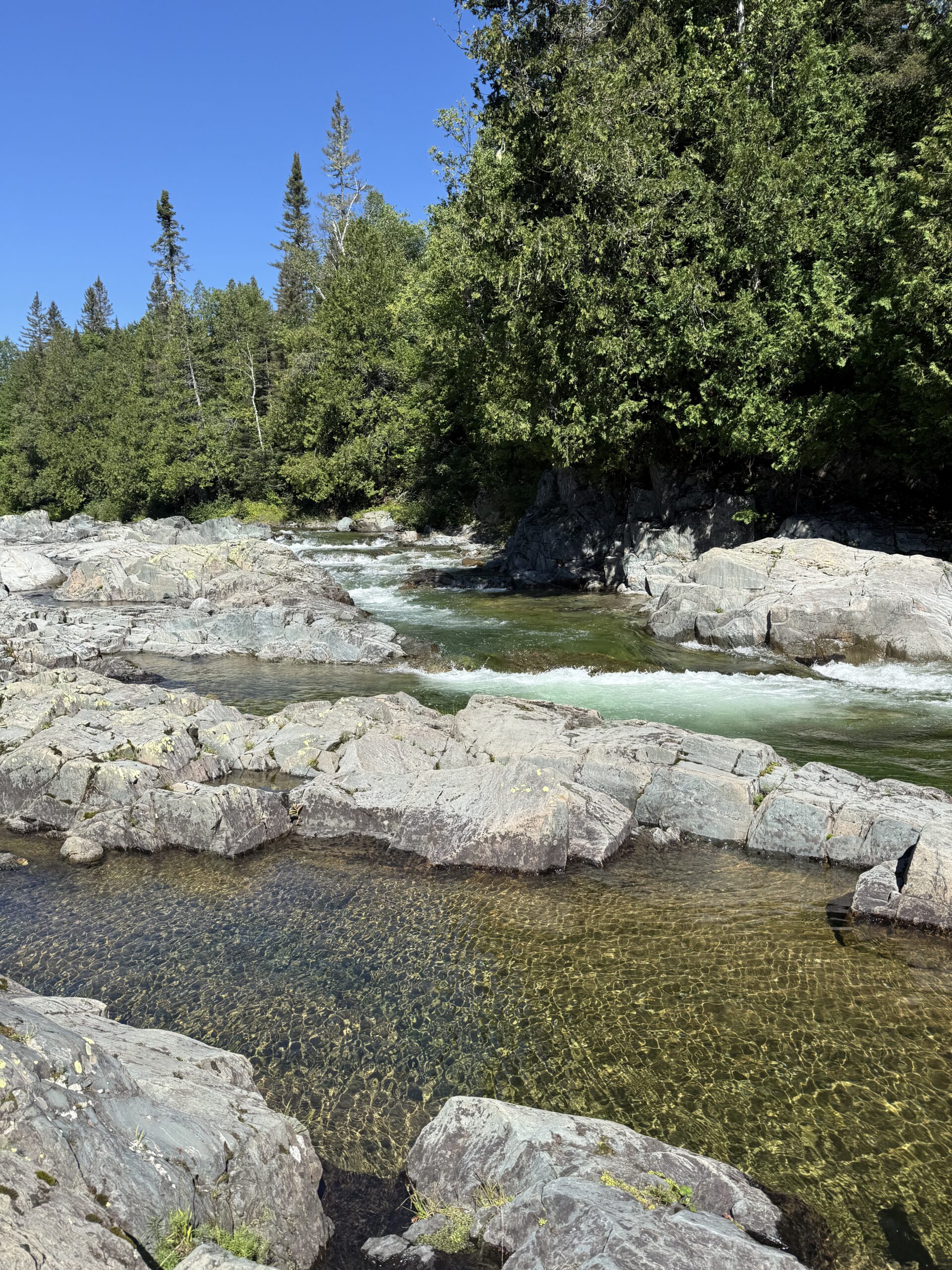 a man standing on a rock in a river, Port-Daniel, Québec, Canada