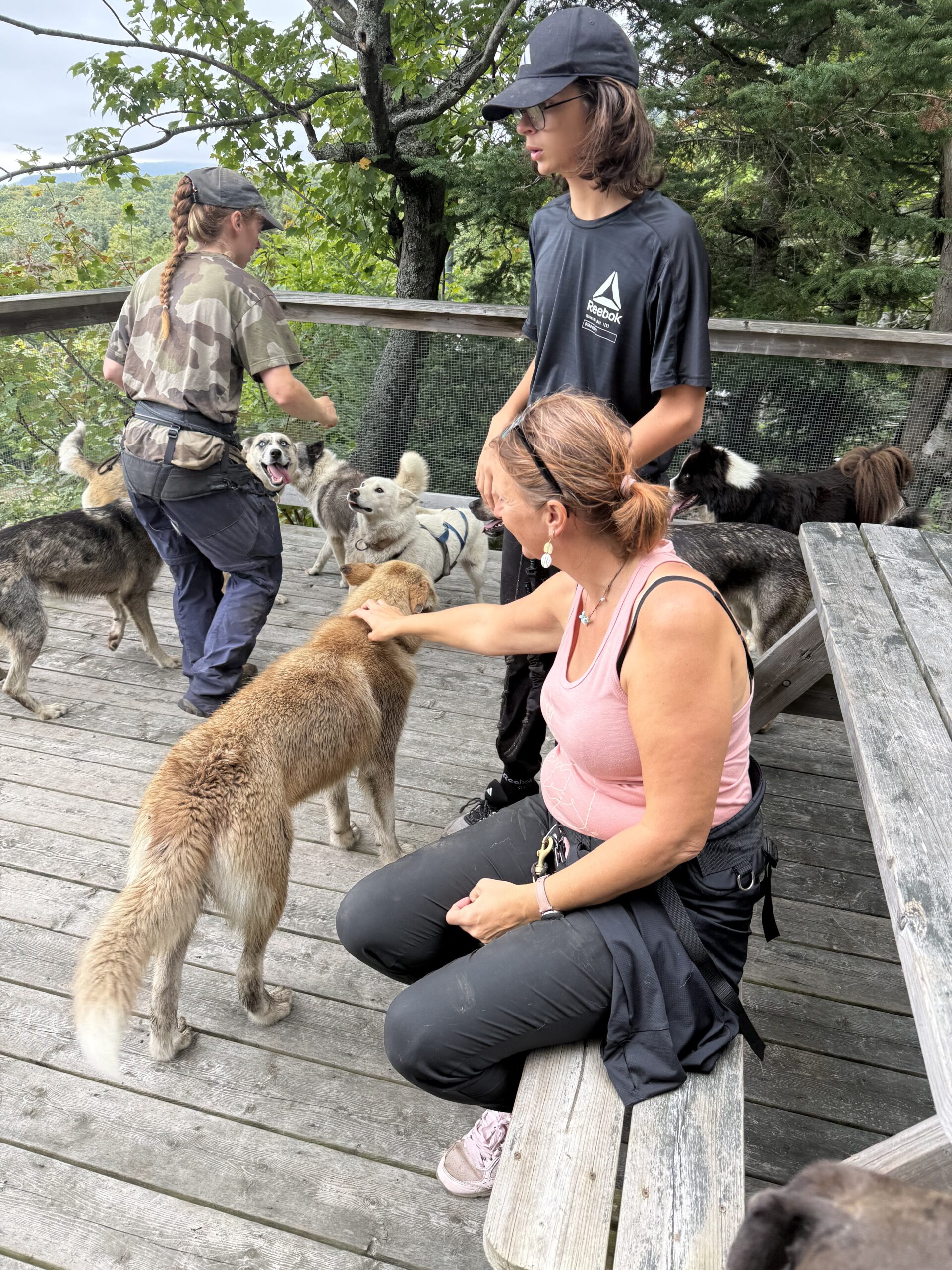 a woman sitting on a wooden bench with a dog, Val-des-Lacs, Québec, Canada
