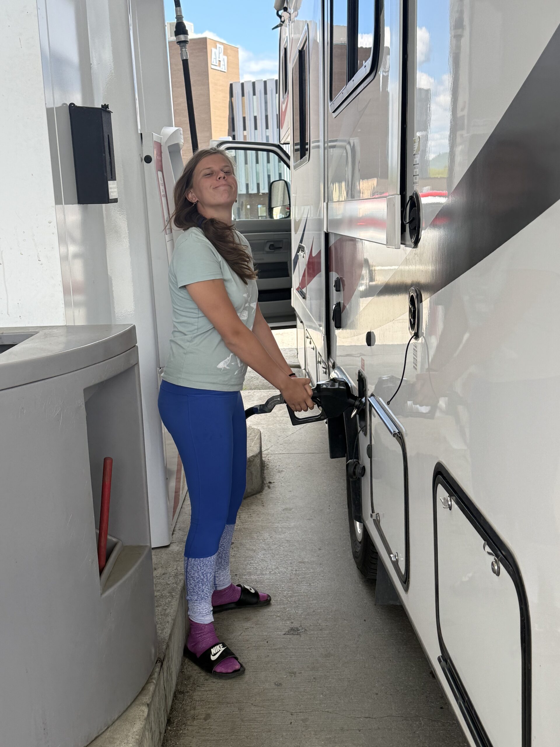 a woman is pumping gas into a truck, Paroisse d'Addington, Nouveau-Brunswick, Canada