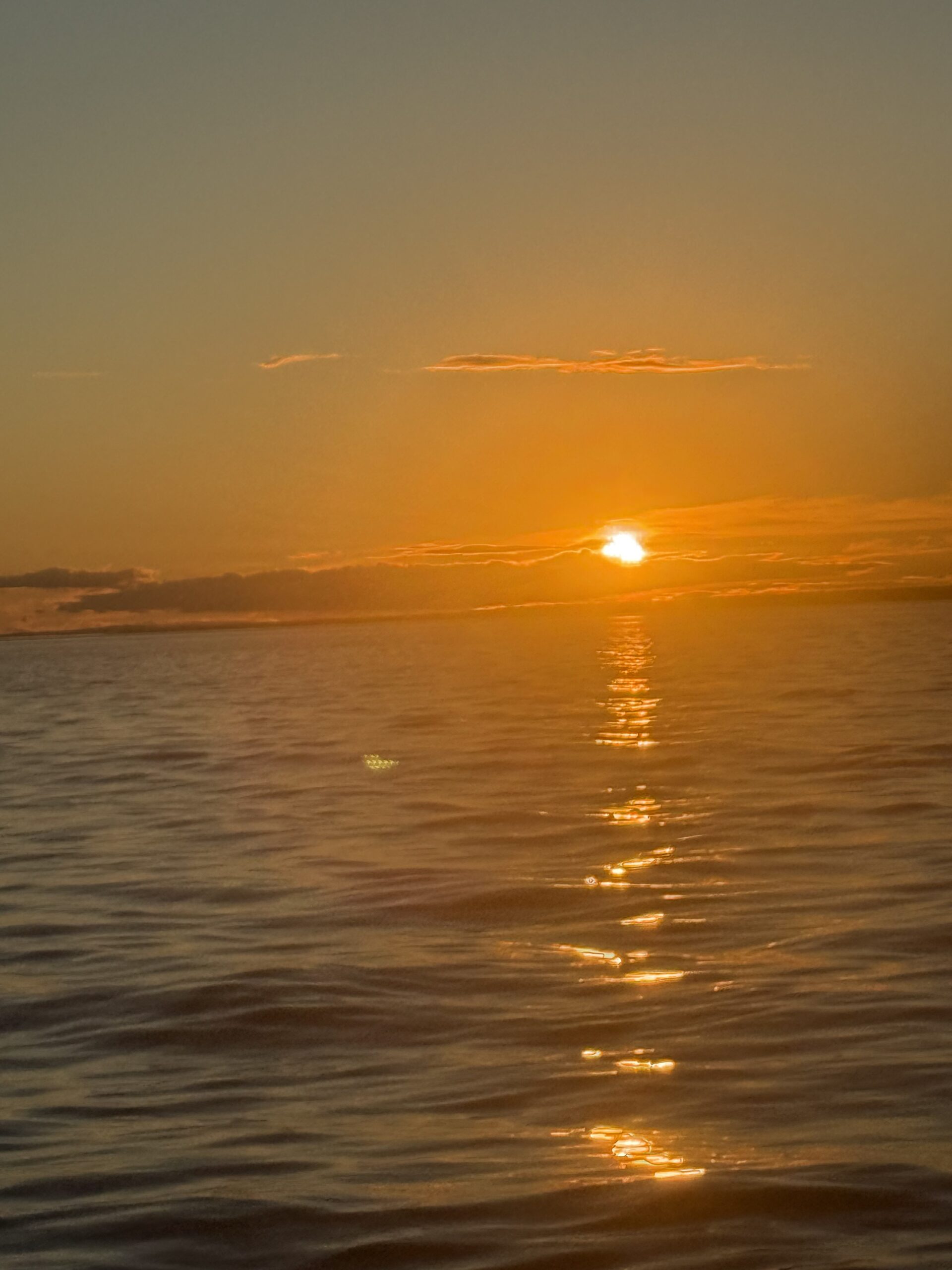a boat is sailing in the ocean at sunset, Rimouski, Québec, Canada