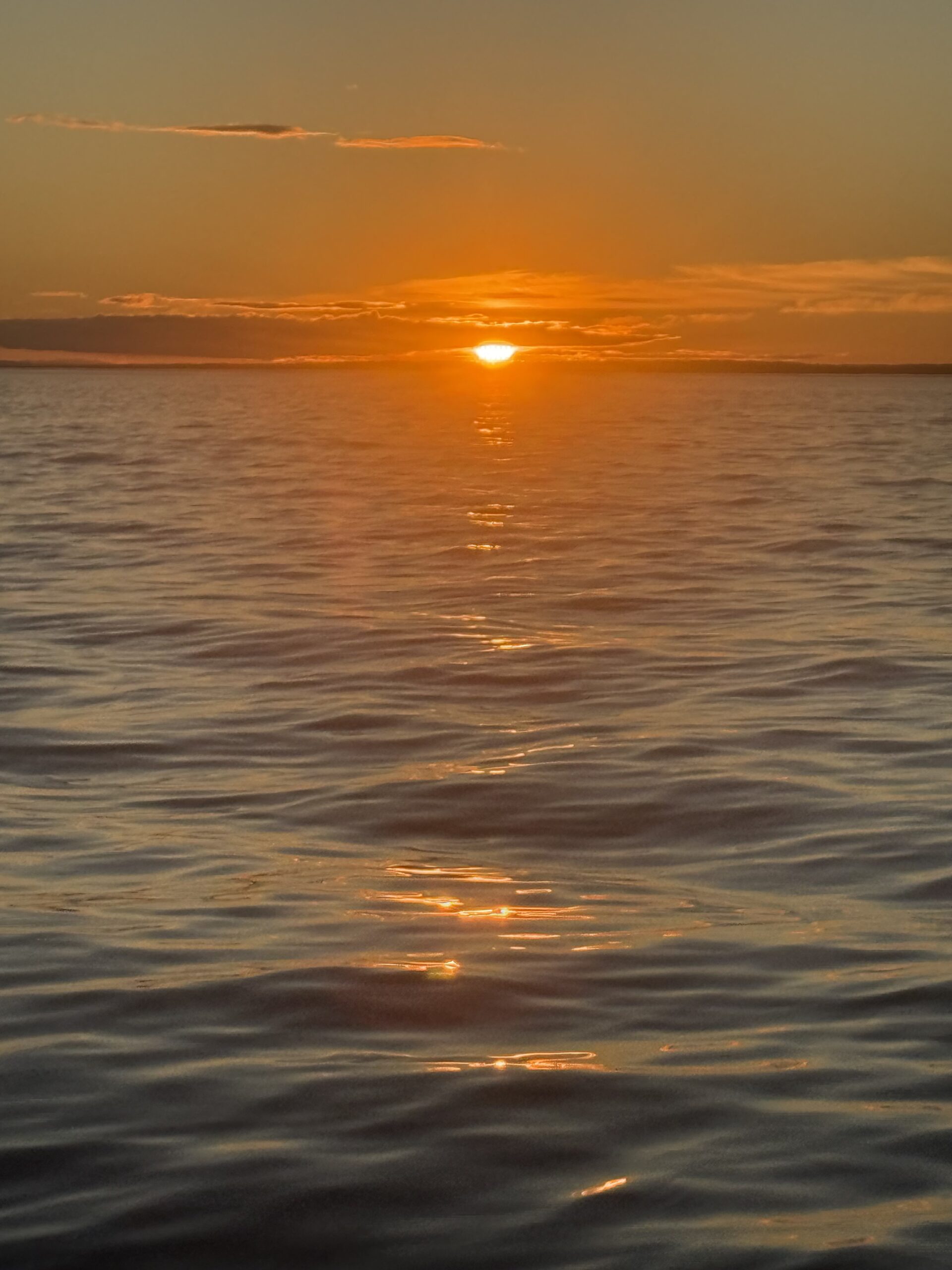 a boat is in the water at sunset, Rimouski, Québec, Canada