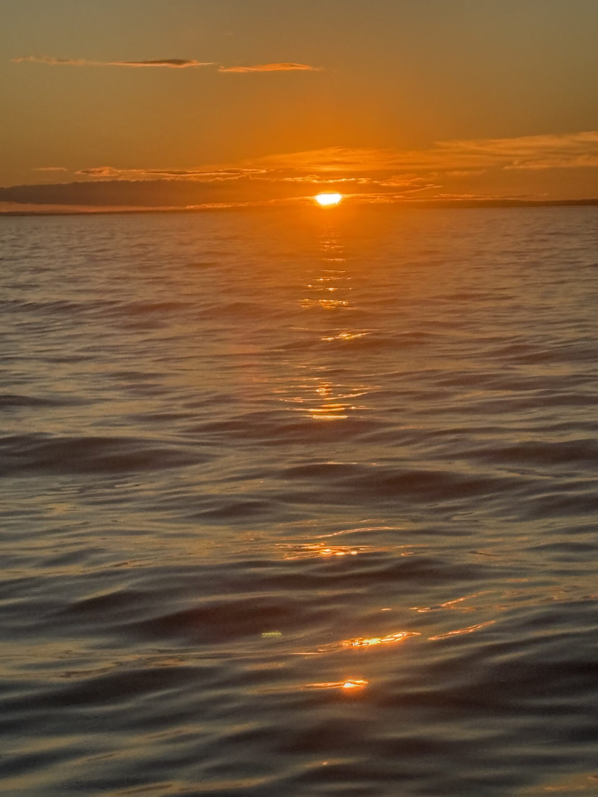 a boat is sailing in the ocean at sunset, Rimouski, Québec, Canada