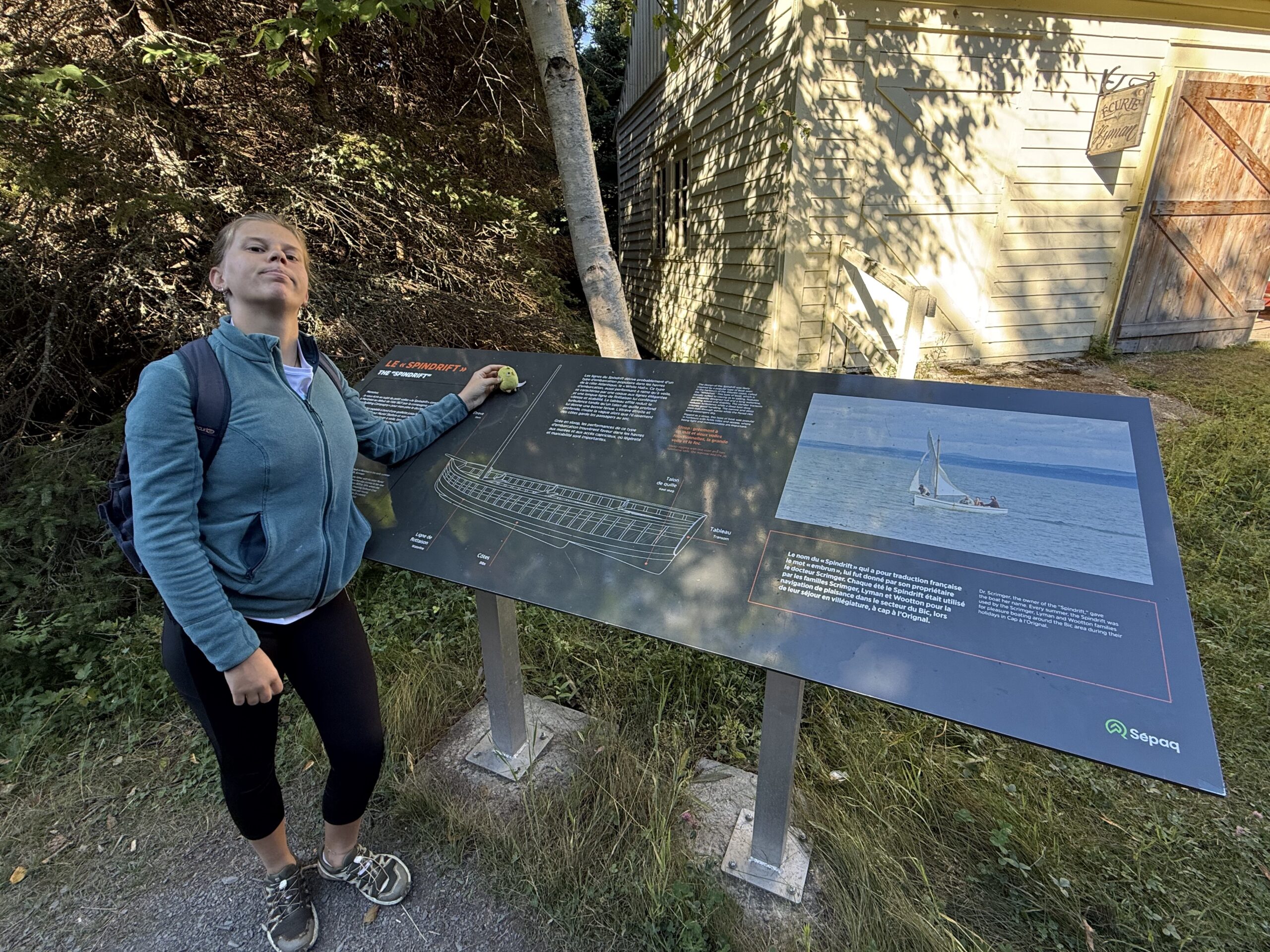 a woman standing next to a sign, Rimouski, Québec, Canada