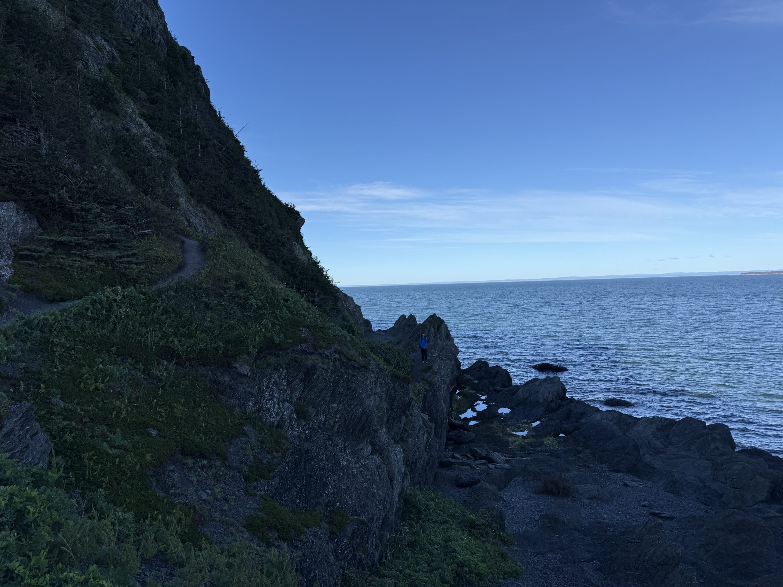 a rocky cliff with a body of water, Rimouski, Québec, Canada