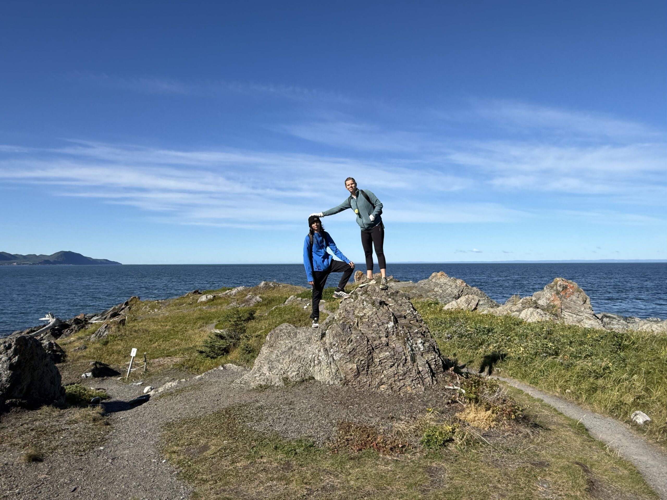 a man standing on a rock by the ocean, Rimouski, Québec, Canada